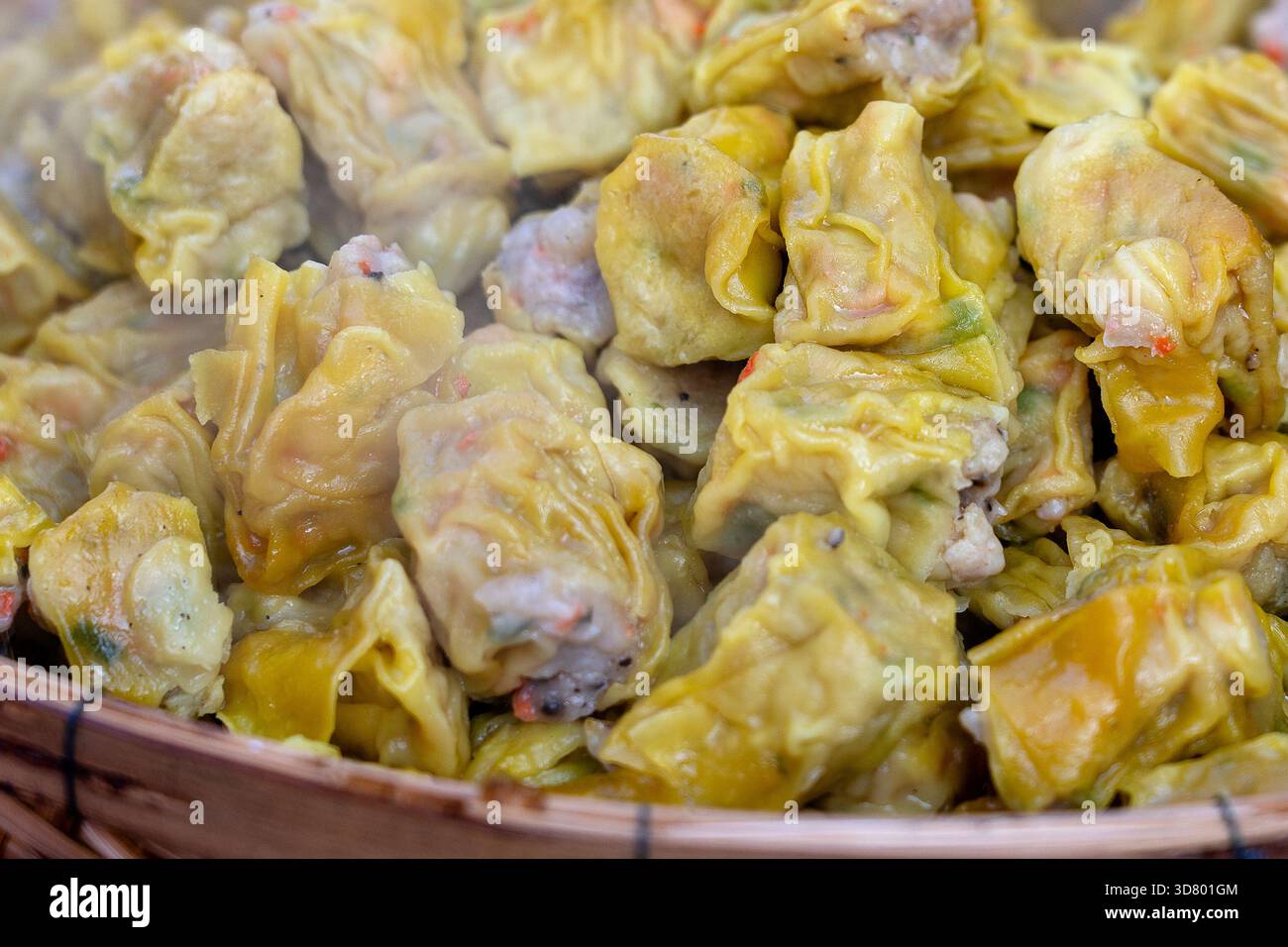 Dimsum cotti al vapore in bambù a street market alimentare in Thailandia, vicino. Dim sum di un piatto cinese di piccole al vapore o fritte gnocchi di salato contenente var Foto Stock