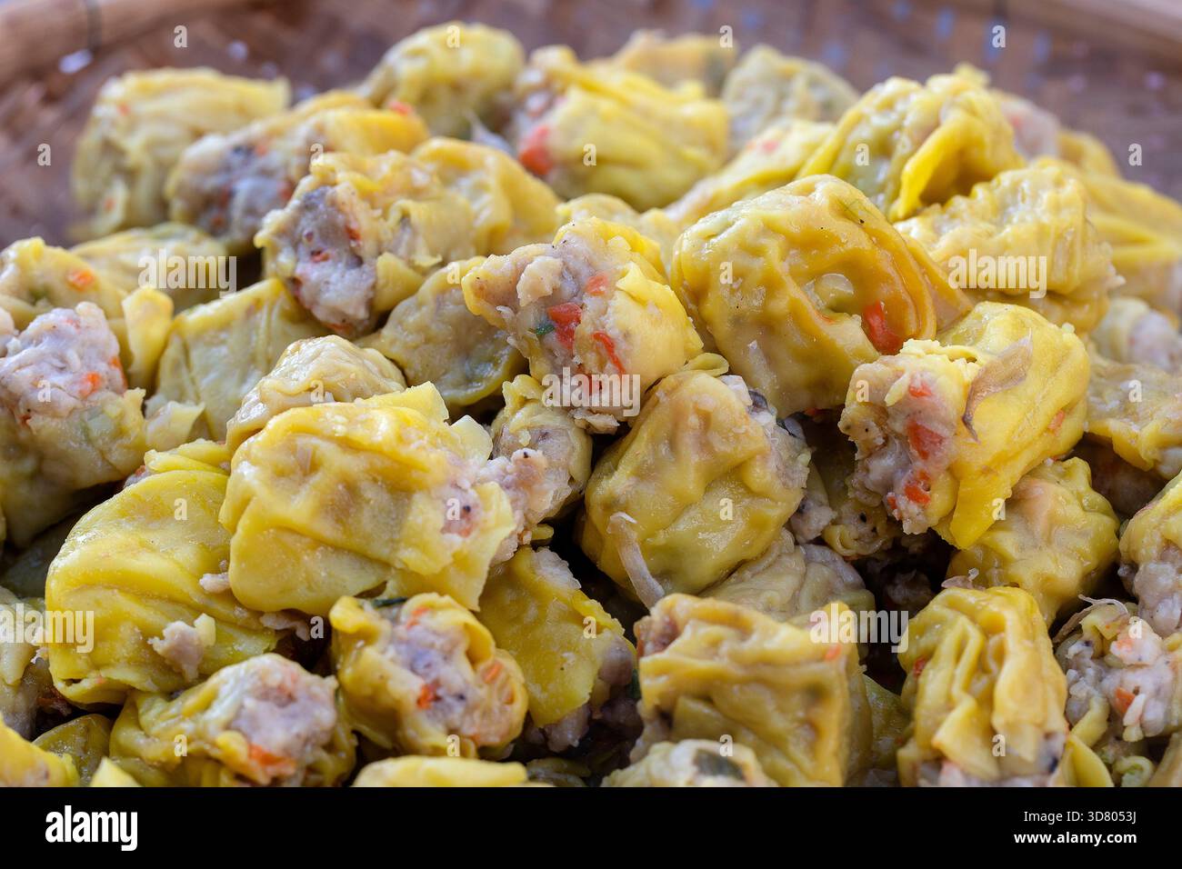 Dimsum cotti al vapore in bambù a street market alimentare in Thailandia, vicino. Dim sum di un piatto cinese di piccole al vapore o fritte gnocchi di salato contenente var Foto Stock