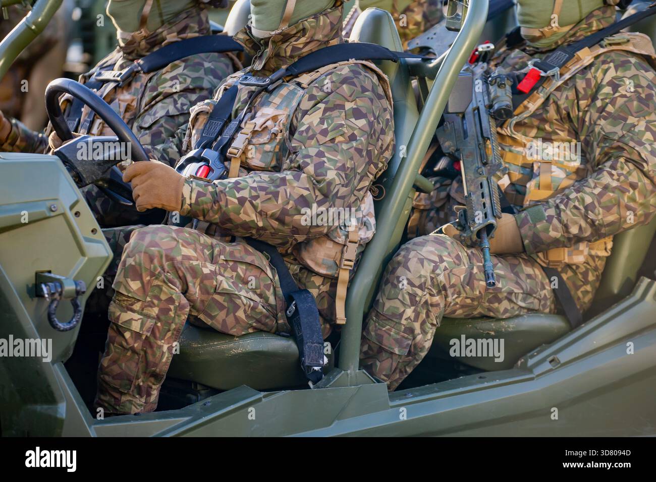 Soldati della NATO in completo equipaggiamento mimetico che cavalcano su un veicolo militare leggero, dimostrando la mobilità dell'alleanza, la capacità tattica e rafforzando il regio Foto Stock