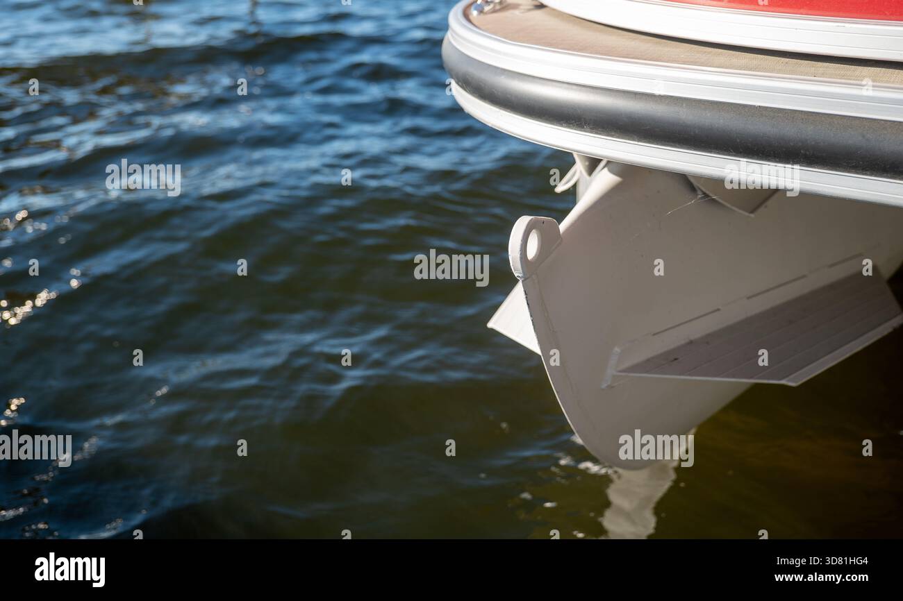 Primo piano dell'estremità anteriore di un tubo di pontone su un lago ondulato. Foto Stock