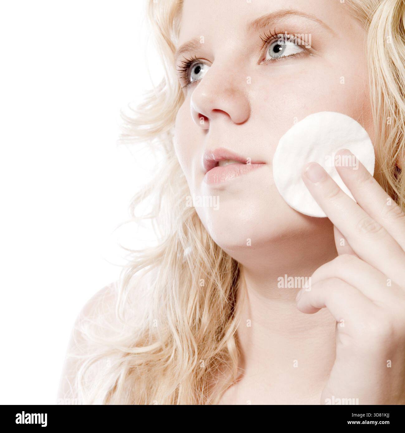 Ritratto in studio di una giovane donna bionda che si toglie il trucco Foto Stock