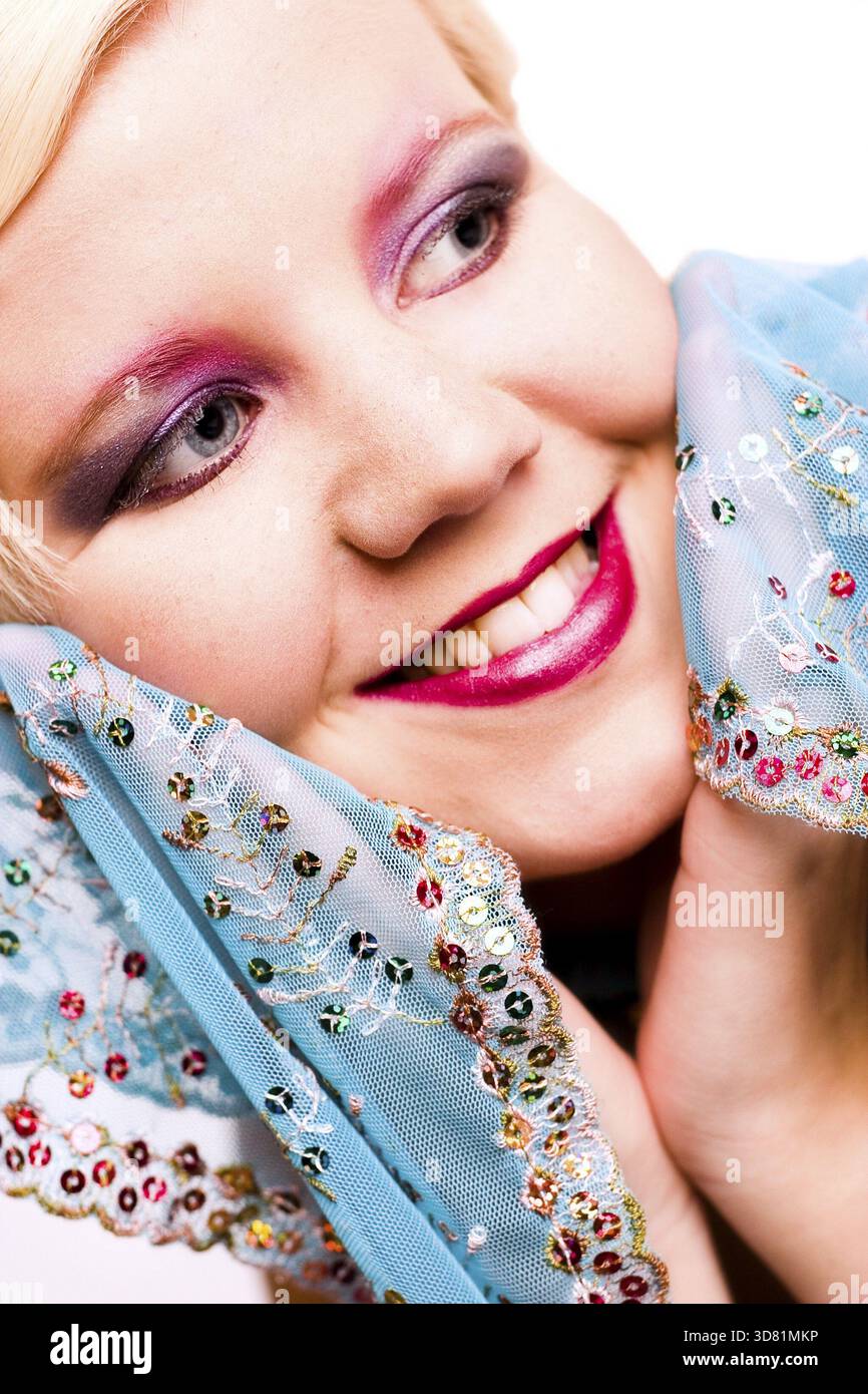 Ritratto in studio di una giovane donna bionda che ama la sua sciarpa Foto Stock