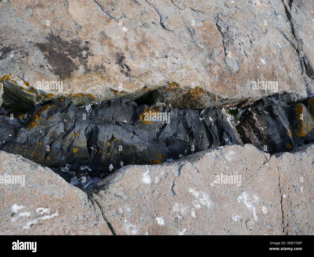 Crepaccio nella roccia con roccia più scura sotto Foto Stock