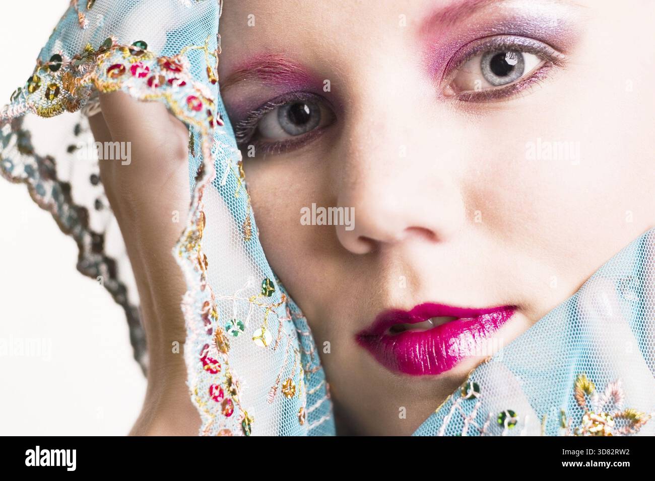 Ritratto in studio di una giovane donna bionda che si diverte con la seta Foto Stock