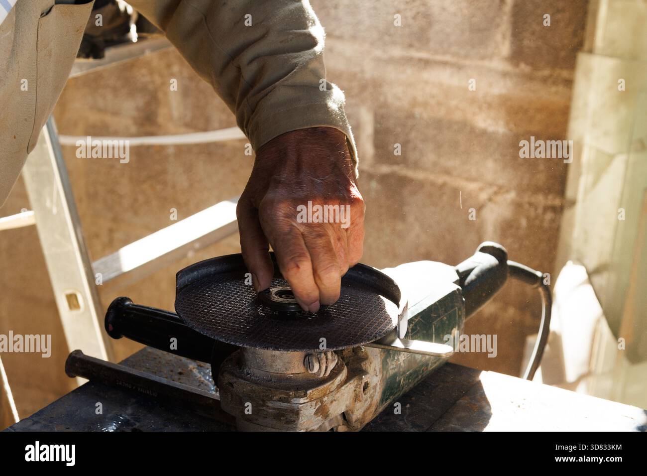 Le mani anziane finalizzano l'utensile di rettifica, le mani intemprate regolano con cura le parti della macchina di rettifica Foto Stock
