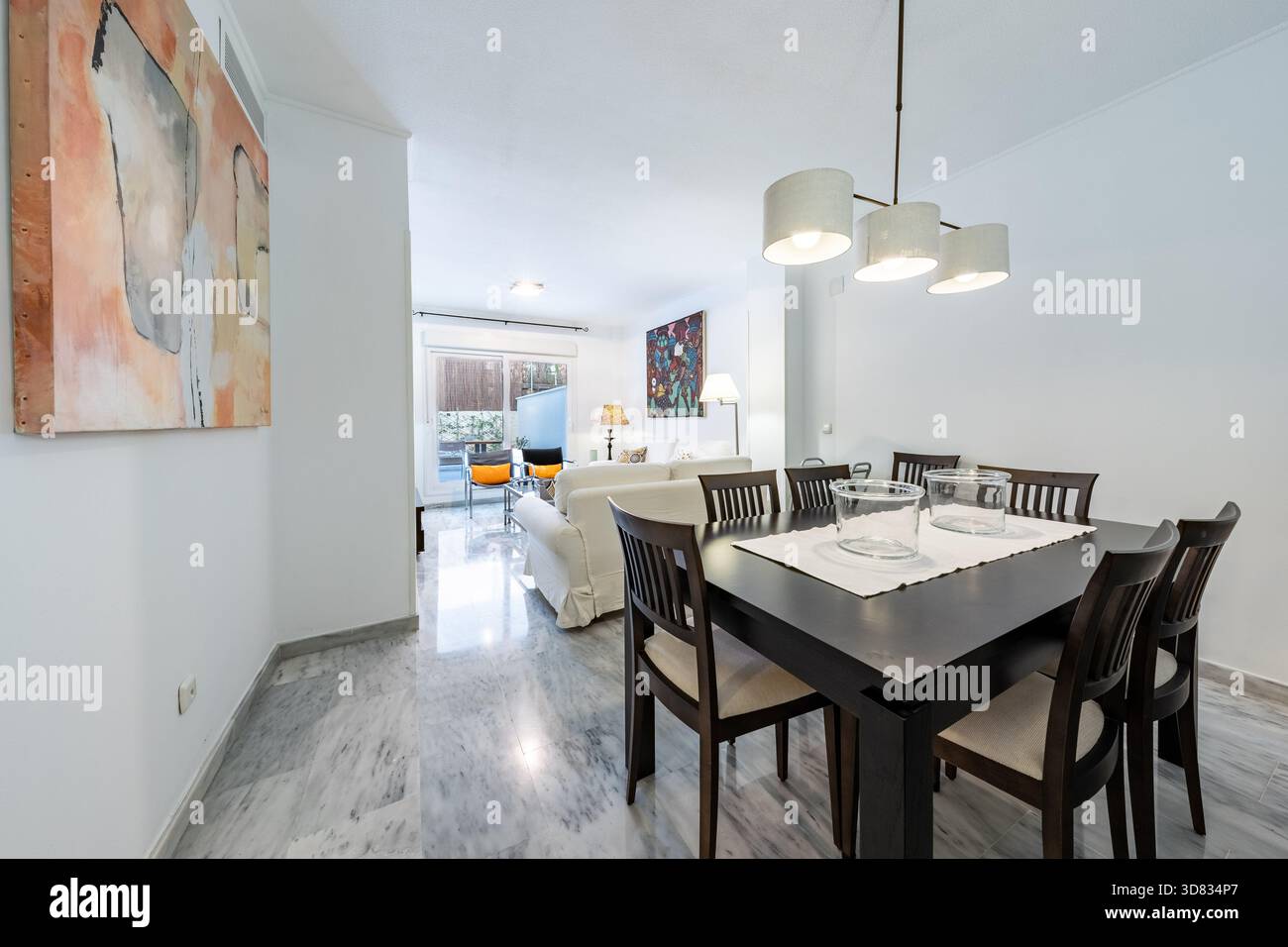 Sala da pranzo con pavimento in marmo e lampadario in interni di casa mediterranea Foto Stock