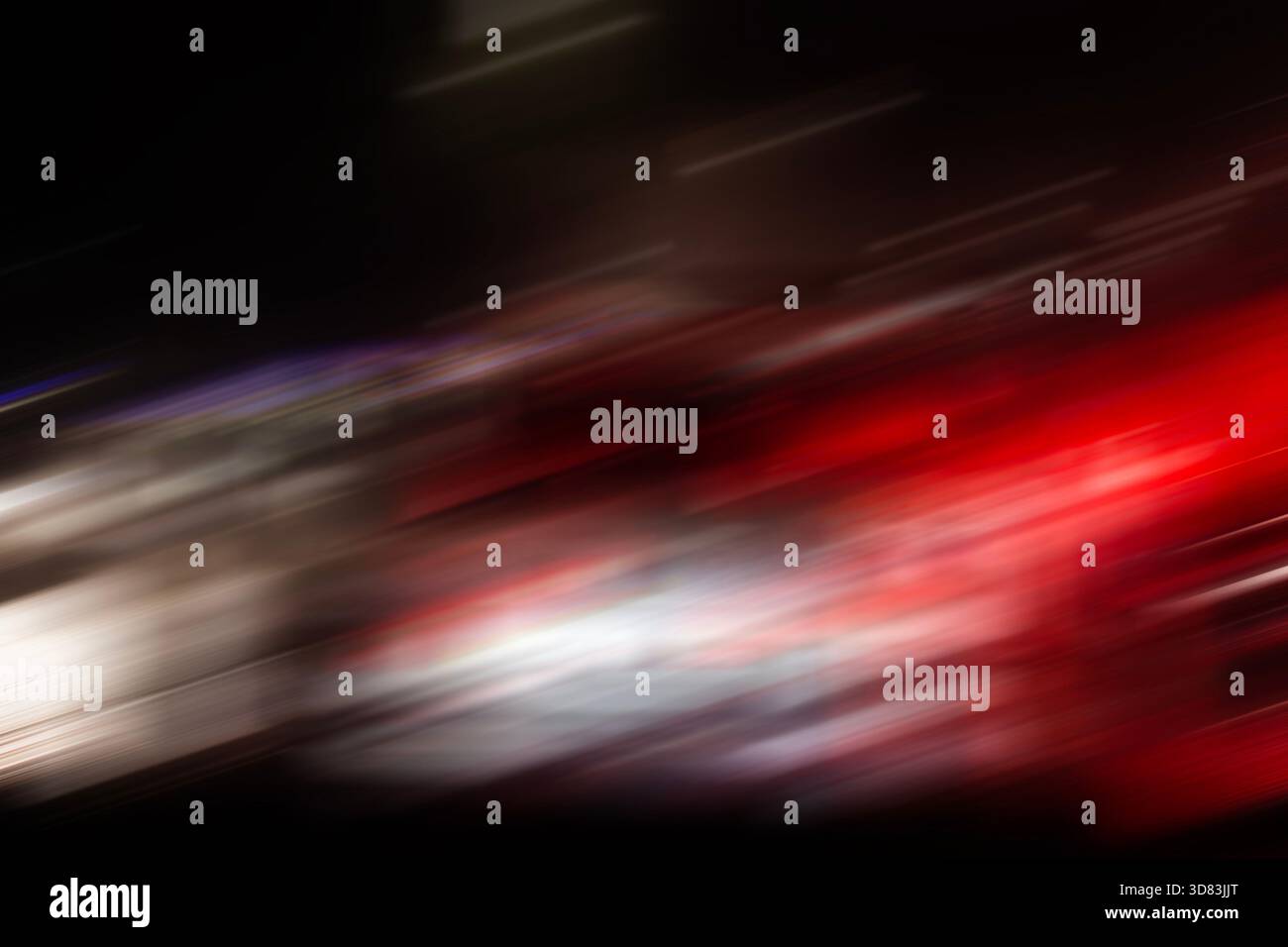 Una sfocatura astratta del movimento di luci rosse e bianche per auto di notte, che crea un senso di alta velocità ed energia. Foto Stock