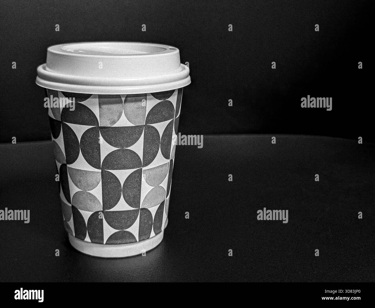 tazza di caffè sulla scrivania di legno accanto a un computer portatile che simboleggia la routine mattutina di lavoro remoto Foto Stock