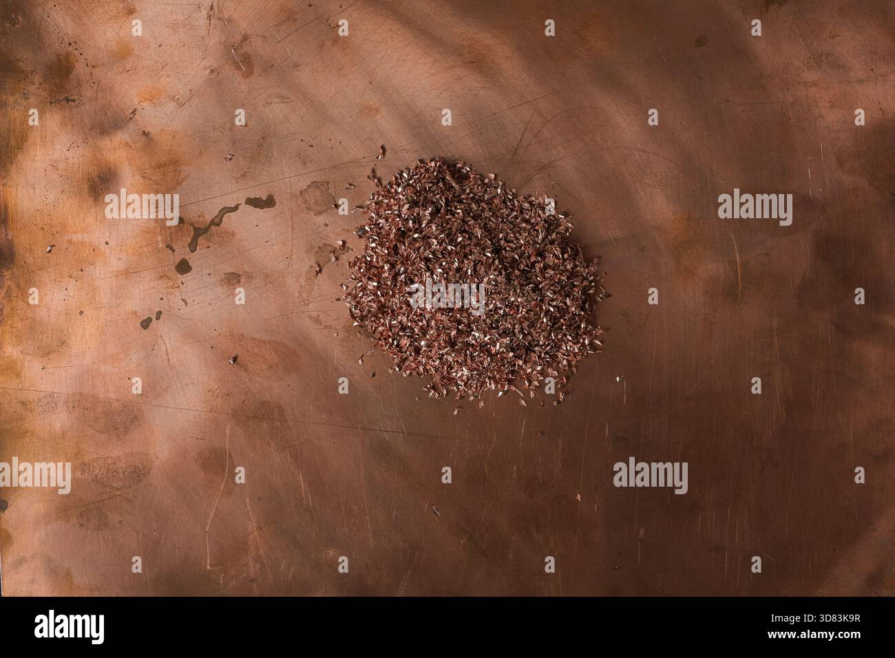 Un mucchio di trucioli di rame su una superficie metallica di rame graffiata. Rottami di rame. Background industriale. Foto Stock