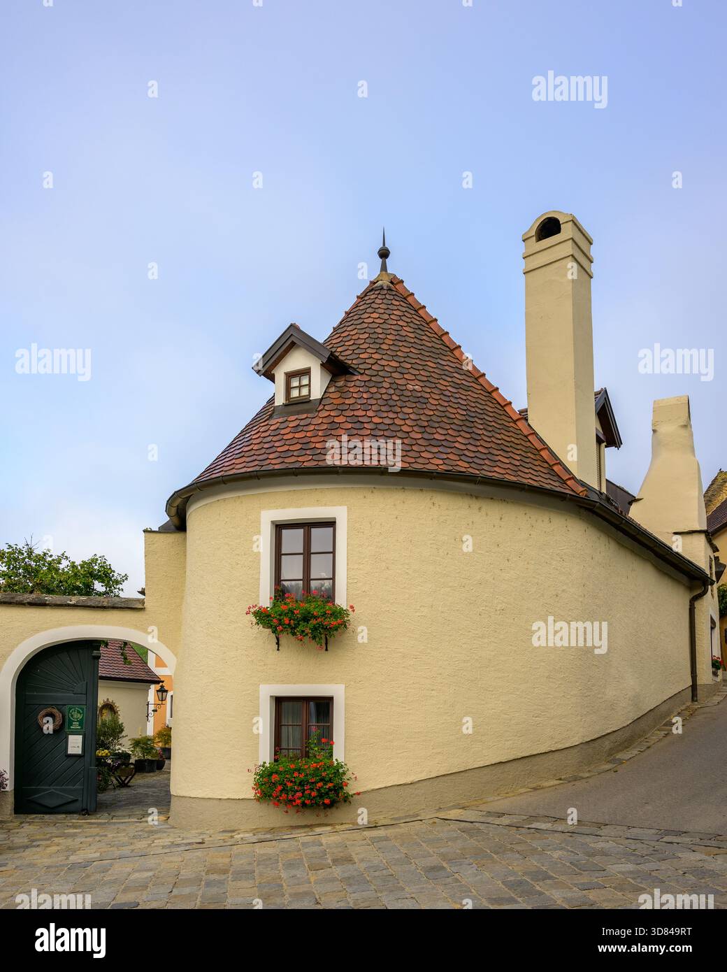 Spitz, Austria - 11 ottobre 2023: Una casa dietro l'angolo si erge in città sotto un cielo autunnale nuvoloso creando un'atmosfera storica. Foto Stock