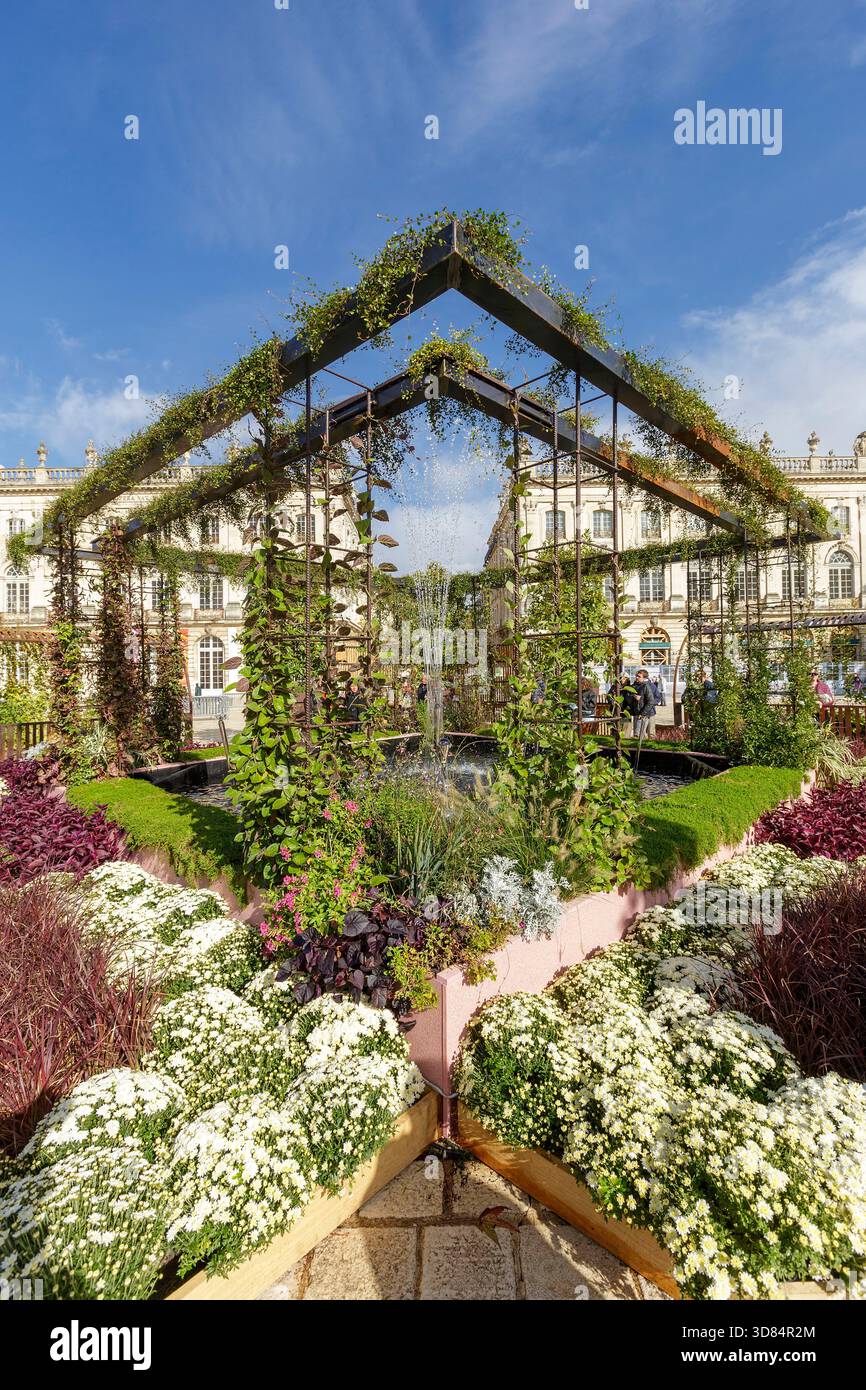 Francia, Meurthe et Moselle, Nancy, piazza Stanislas (ex piazza reale) dichiarata Patrimonio dell'Umanità dall'UNESCO, costruita sotto Stanislas Leszczynski, re di Polonia e ultimo duca di Lorena nel XVIII secolo, durante l'evento Jardin Ephemere del 2025, che celebra il 100° anniversario dell'inizio dell'Art Deco, basato sul tema de graines d'art deco (dai semi di stile Art Deco, sulla piazza dell'Hotel Resline, sulla facciata dell'hotel. del Teatro dell'Opera sulla sinistra, cornice con piante fatte per ricordare il Musee Aquarium de Nancy (museo e acquario di Nancy) Foto Stock