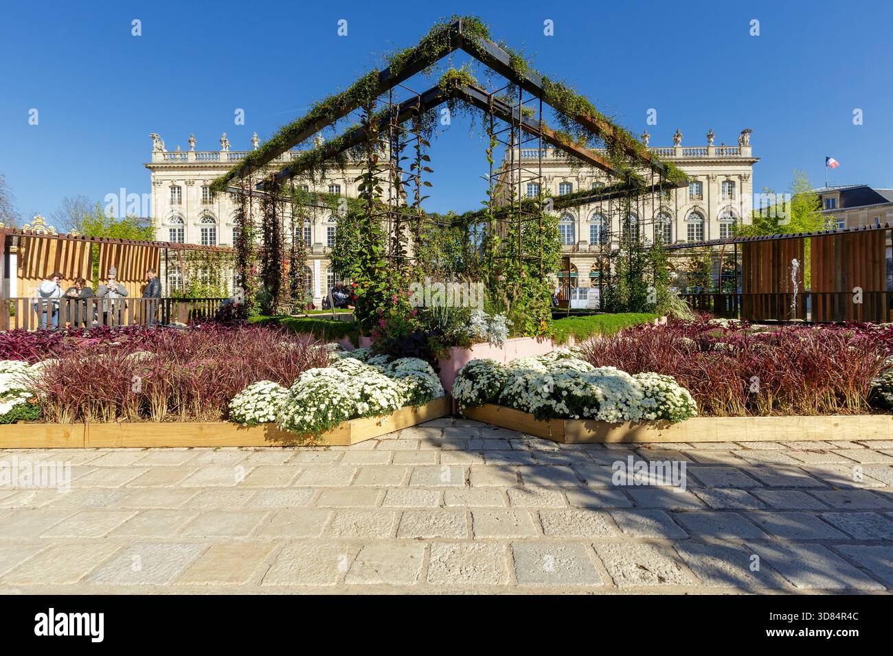 Francia, Meurthe et Moselle, Nancy, piazza Stanislas (ex piazza reale) dichiarata Patrimonio dell'Umanità dall'UNESCO, costruita sotto Stanislas Leszczynski, re di Polonia e ultimo duca di Lorena nel XVIII secolo, durante l'evento Jardin Ephemere del 2025, che celebra il 100° anniversario dell'inizio dell'Art Deco, basato sul tema de graines d'art deco (dai semi di stile Art Deco, sulla piazza dell'Hotel Resline, sulla facciata dell'hotel. del Teatro dell'Opera sulla sinistra, cornice con piante fatte per ricordare il Musee Aquarium de Nancy (museo e acquario di Nancy) Foto Stock