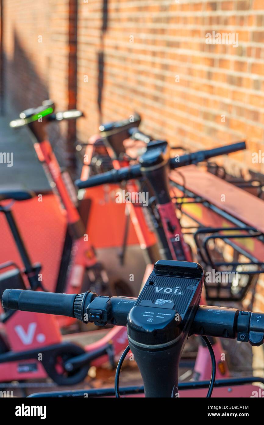 Voi. Scooter elettrici lasciati presso una stazione di ricarica o punto di prelievo e rientro nel centro di Portsmouth, Regno Unito Foto Stock