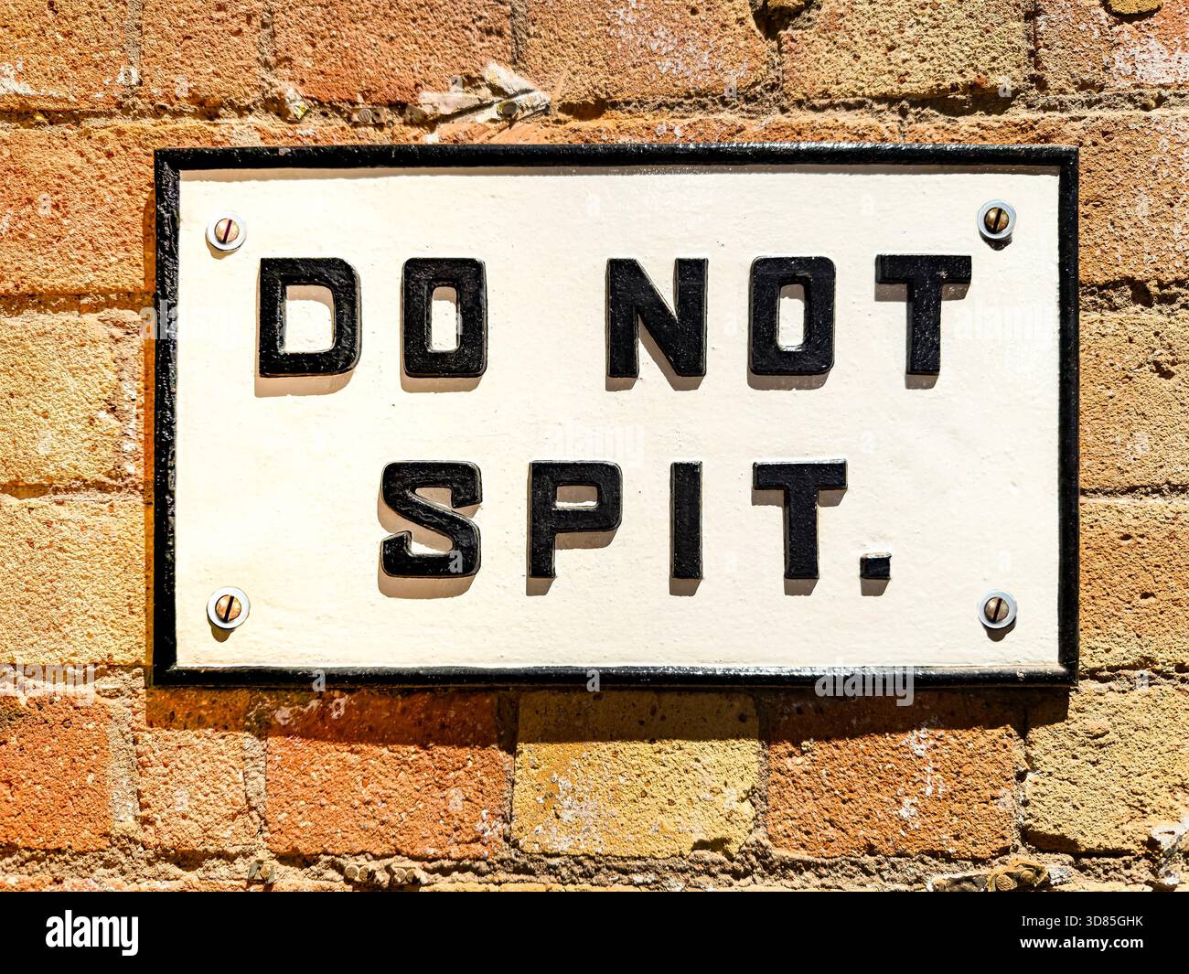 Cartello ferroviario in metallo fuso vintage con testo nero in grassetto non spillare attaccato a una parete in mattoni intemprati - Immagine stock catturata con smartphone