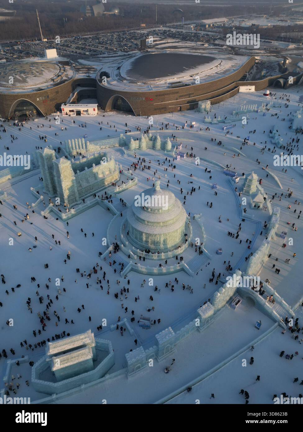 Vista aerea di un paesaggio innevato caratterizzato da sculture di ghiaccio e folle di persone vicino all'Harbin Ice and Snow World, che creano uno spettacolo invernale abbagliante Foto Stock