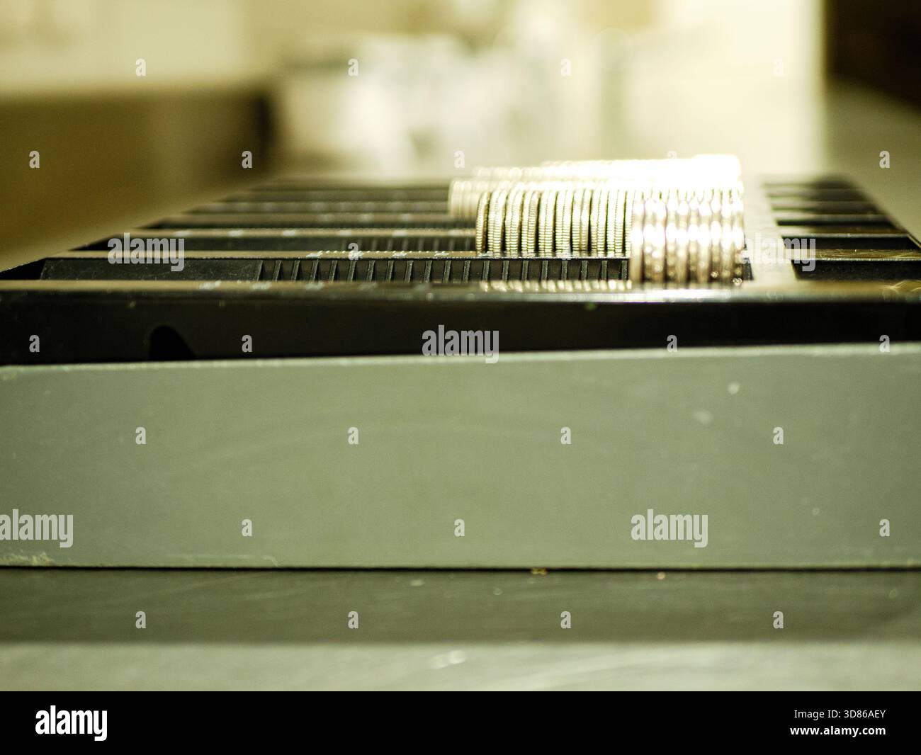 Angolo laterale delle pile di monete allineato in un vassoio nero di smistamento del denaro utilizzato nella gestione professionale del contante e nelle operazioni di pagamento al dettaglio quotidiane Prof Photo Foto Stock