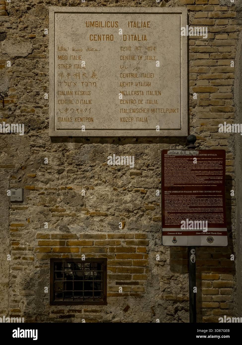 Insegna multilingue nel centro storico di Rieti che segna il centro geografico d'Italia Foto Stock