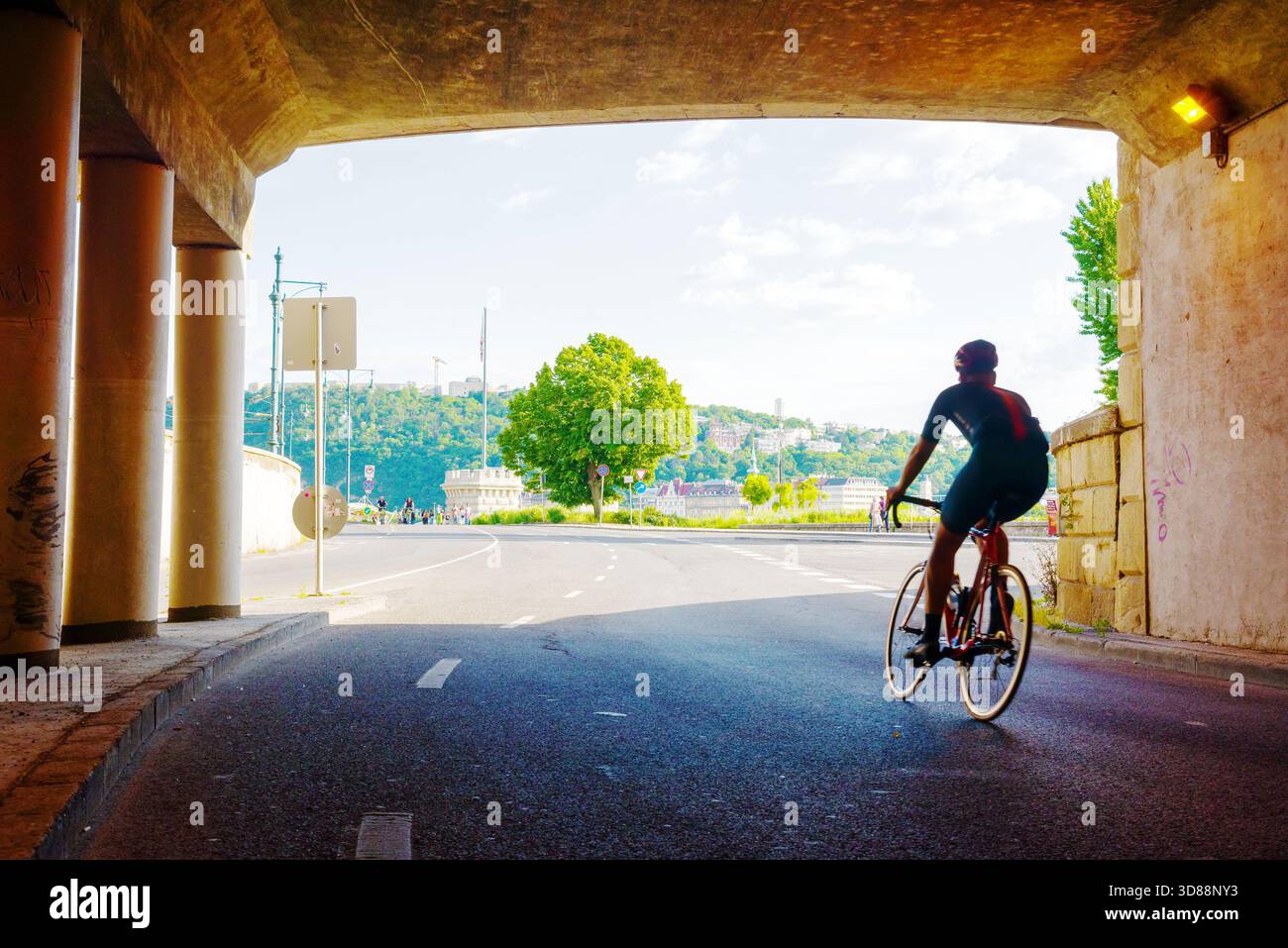 Silhouette del ciclista che esce dal tunnel Foto Stock