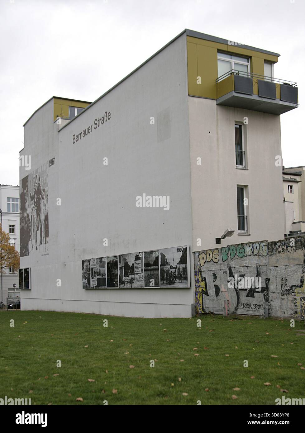 Muro di Berlino, Germania. La sua costruzione iniziò il 13 agosto 1961 e cadde il 9 novembre 1989. Il governo della Repubblica Democratica tedesca (RDT) costruì questa barriera, lunga più di 150 km, per isolare completamente Berlino Est dal resto della RDT. Memoriale del muro di Berlino su Bernauer Strasse, Mitte. Edificio con pannelli che mostrano fotografie storiche sul muro. Dopo la sua costruzione, la polizia della Germania Est chiuse le porte esistenti su Bernauer Strasse. Le finestre delle case furono gradualmente murate dopo che diversi berlinesi le usarono per fuggire. Foto Stock