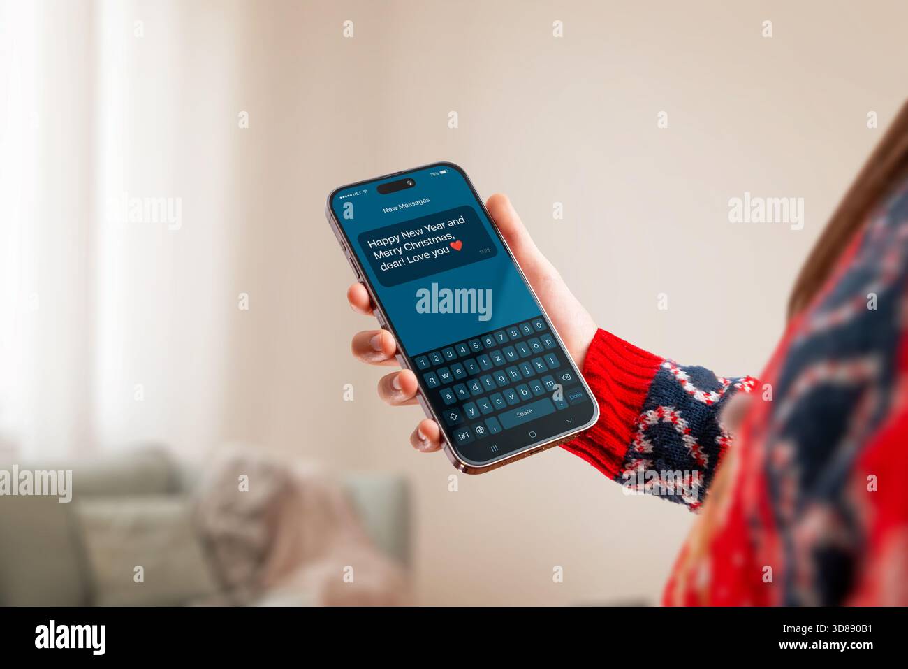 Modello di telefono natalizio con maglione natalizio e messaggio natalizio sullo schermo, perfetto per promozioni invernali, saluti, app mobili e promozioni stagionali Foto Stock