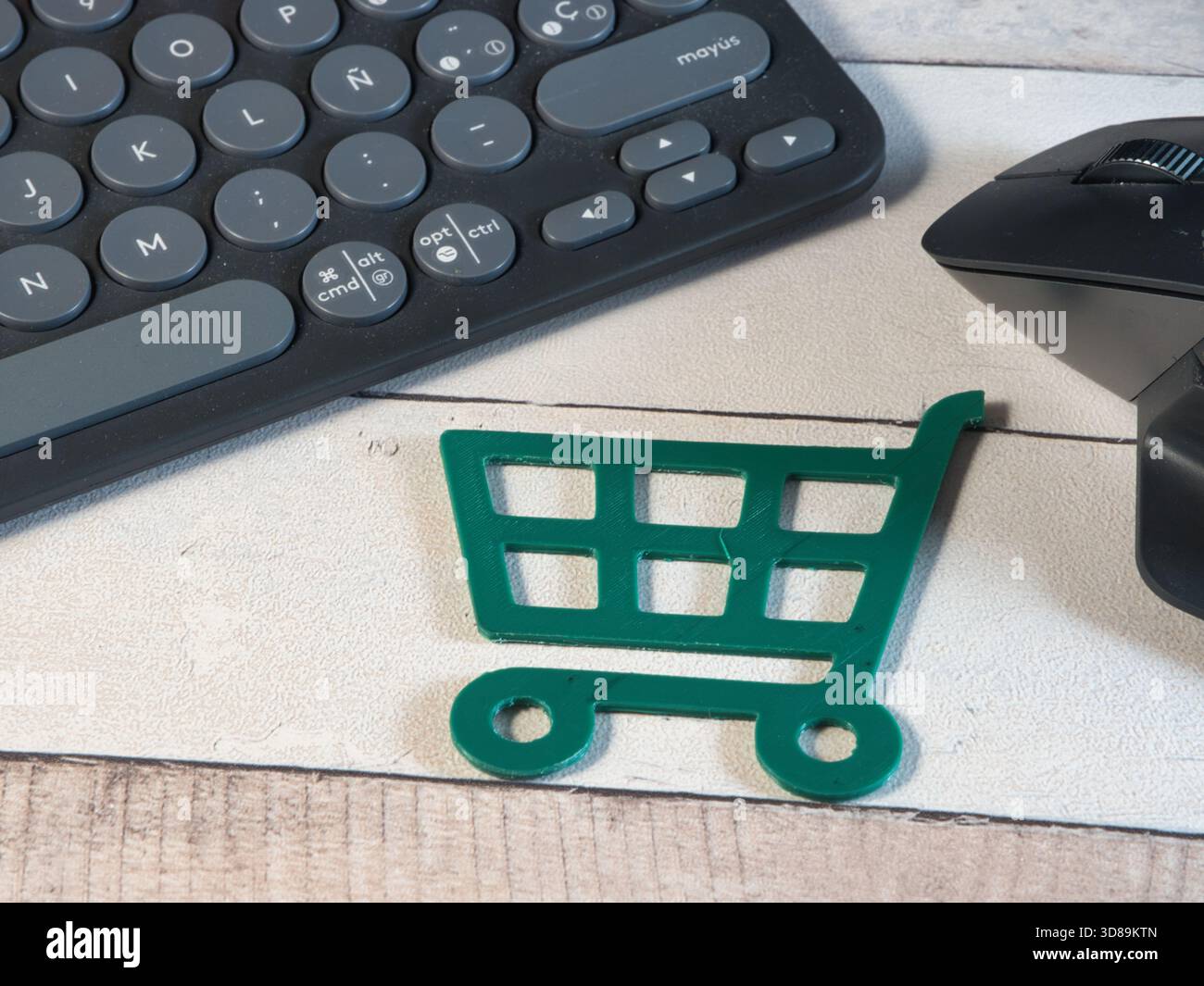 Shopping online: Tastiera, mouse, carrello - Vista dall'alto di un carrello verde in miniatura con tastiera e mouse per computer. Rappresenta il comfort Foto Stock