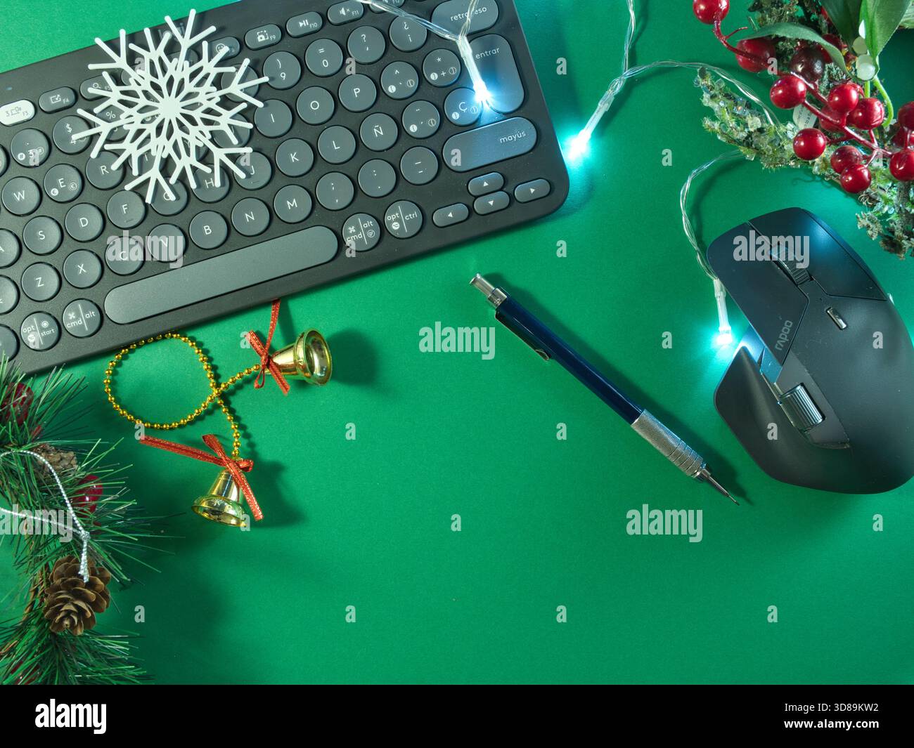 Allestimento per le feste con tastiera - tastiera per computer con decorazioni natalizie e luci fiabesche su sfondo verde vivace, Foto Stock