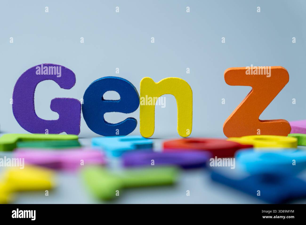 La frase GEN Z è scritta in lettere di legno colorate sparse su sfondo grigio. Generazione moderna, nativi digitali, cultura giovanile Foto Stock