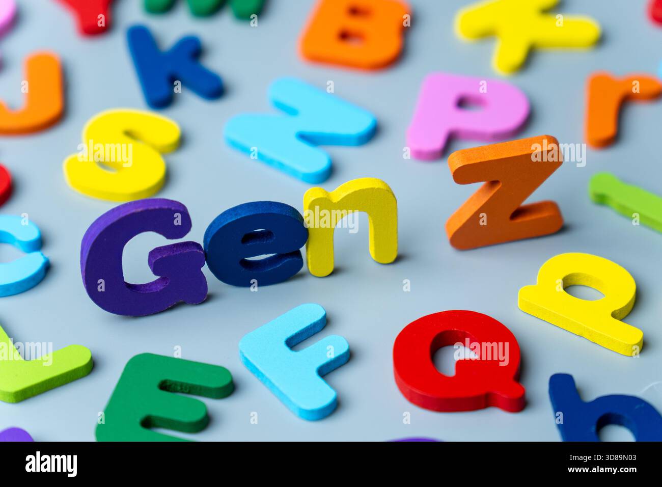 La frase GEN Z è scritta in lettere di legno colorate sparse su sfondo grigio. Generazione moderna, nativi digitali, cultura giovanile Foto Stock