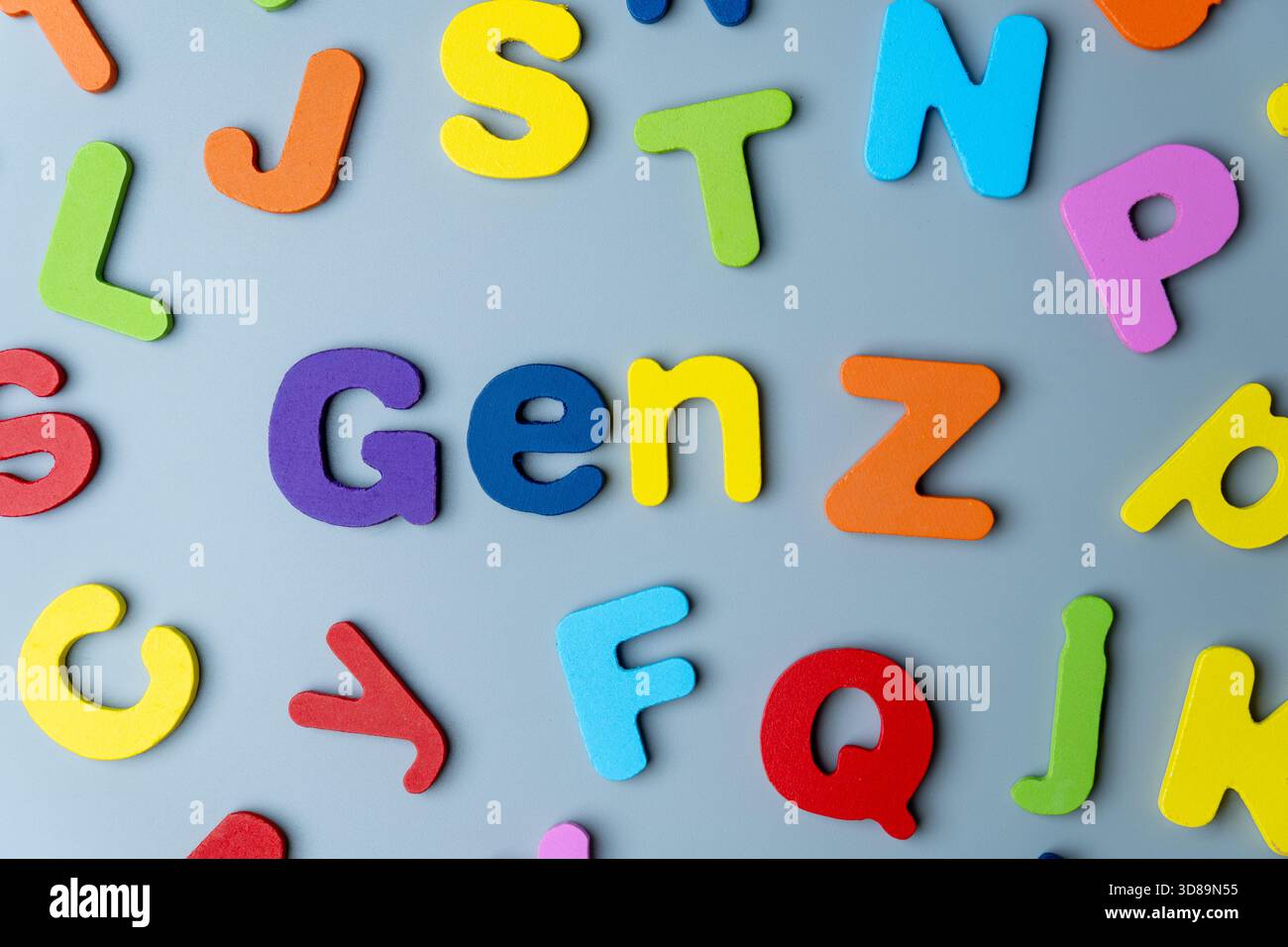La frase GEN Z è scritta in lettere di legno colorate sparse su sfondo grigio. Generazione moderna, nativi digitali, cultura giovanile Foto Stock