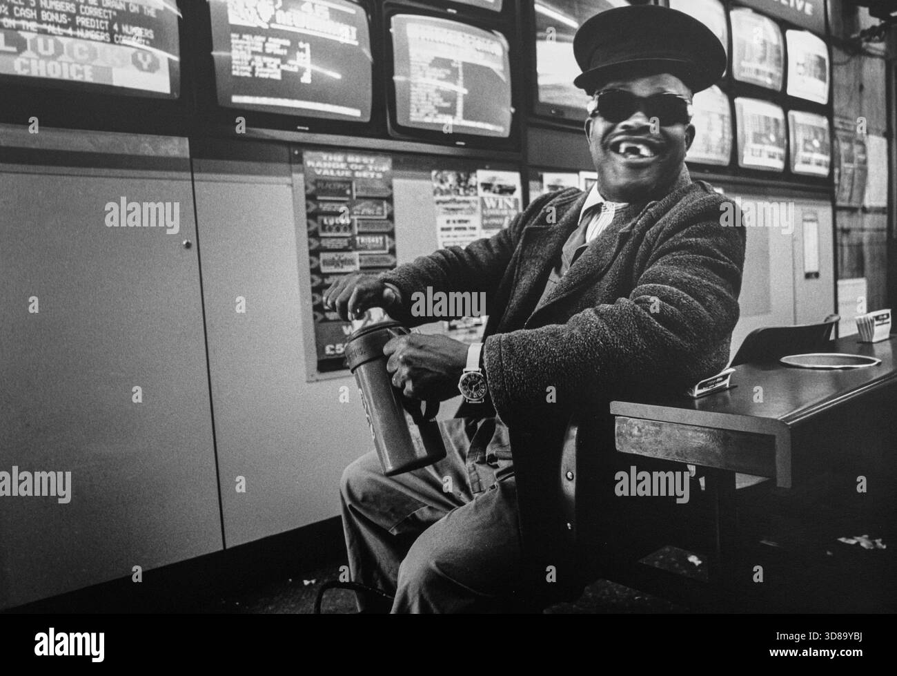 Un cliente in un bookmaker di Brixton su Electric Avenue. Foto Stock