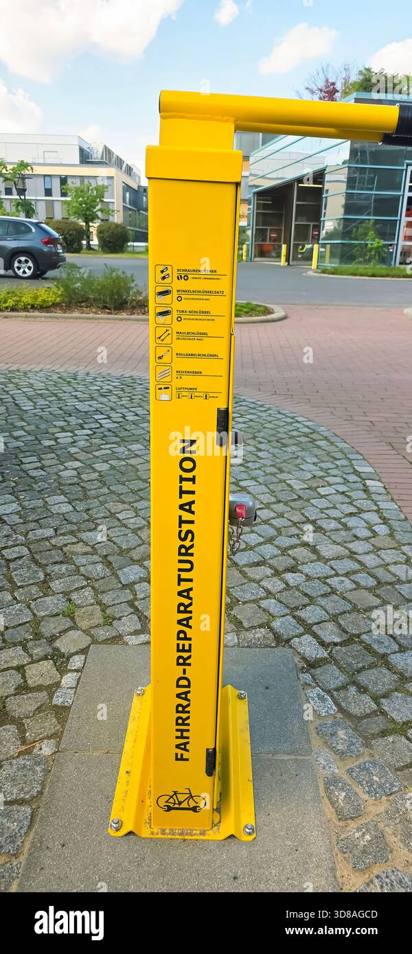 Belin, Germania - 30 maggio 2025: La stazione di riparazione delle biciclette gialle si trova in un ambiente urbano sotto un cielo azzurro. Ospedale - Immagine stock catturata con smartphone