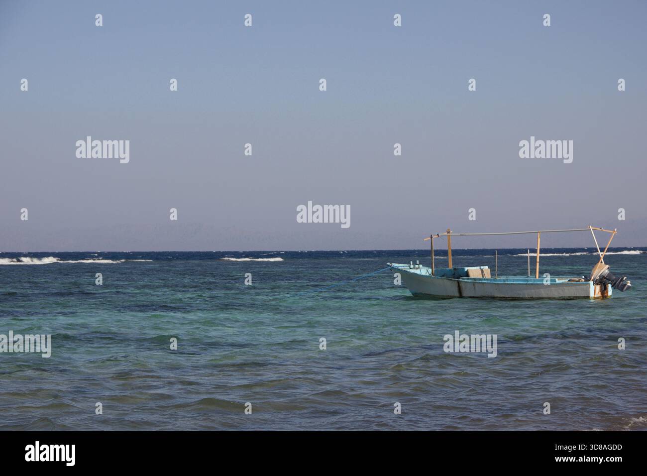 piccola barca da pesca che galleggia sul mare turchese calmo sotto il cielo azzurro, copia spazio Foto Stock