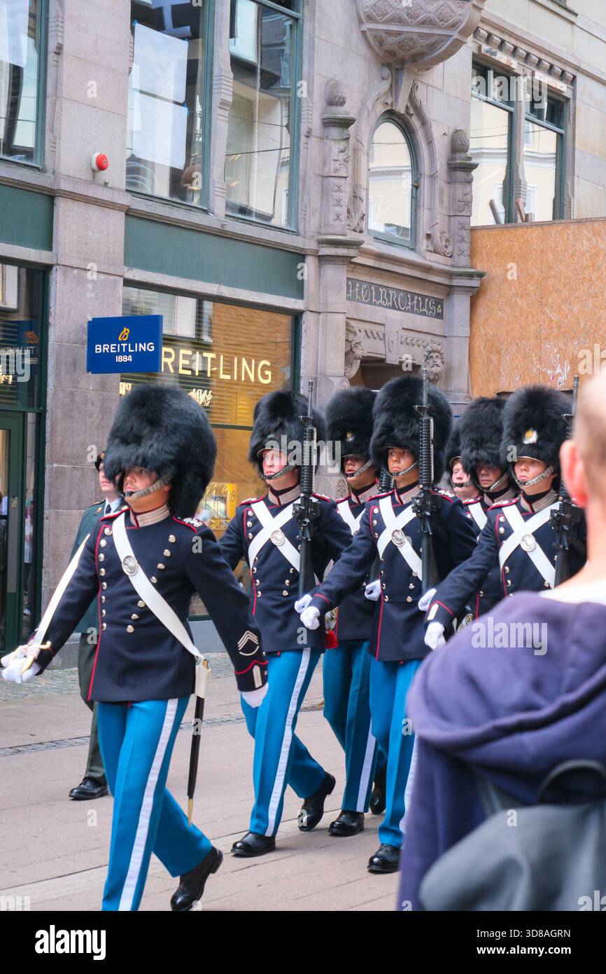 I soldati danesi in alti caschi in pelle d'orso sfilano per le strade di Copenaghen, Danimarca, le loro espressioni focalizzate sono chiaramente visibili Foto Stock