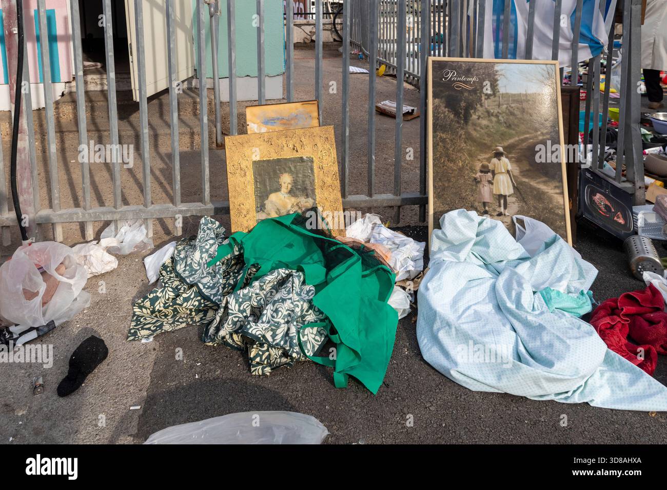 Haifa, Israele, 29 novembre 2025, scartò oggetti come vecchi dipinti, tessuti e sacchetti di plastica accumulati sulla strada dell'asfalto accanto a un bar di metallo Foto Stock