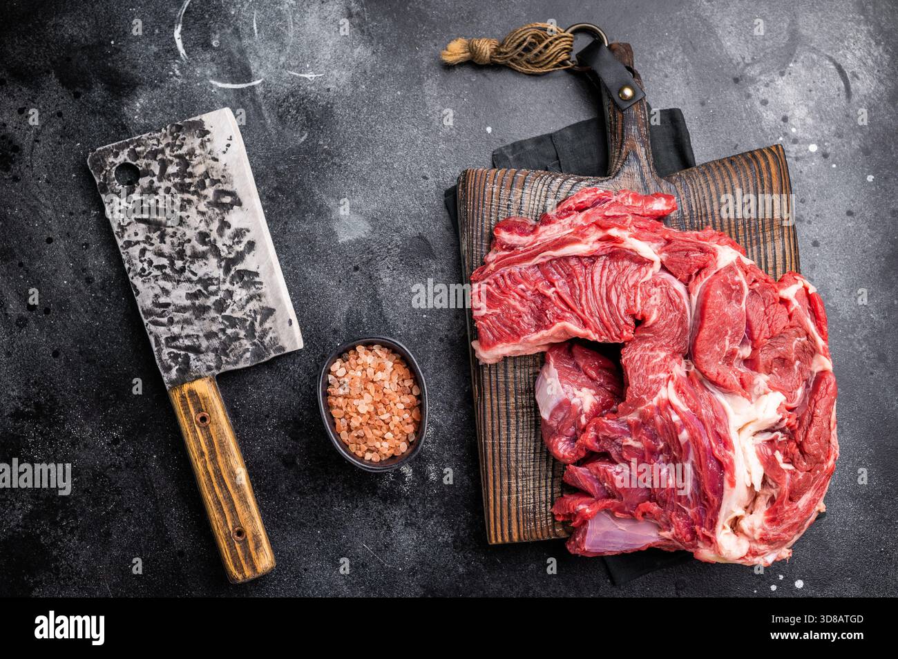 Ottima carne al collo di manzo cruda marmorizzata, perfetta per arricchire le tue ricette preferite con sapori ricchi. sfondo nero. vista dall'alto. Foto Stock
