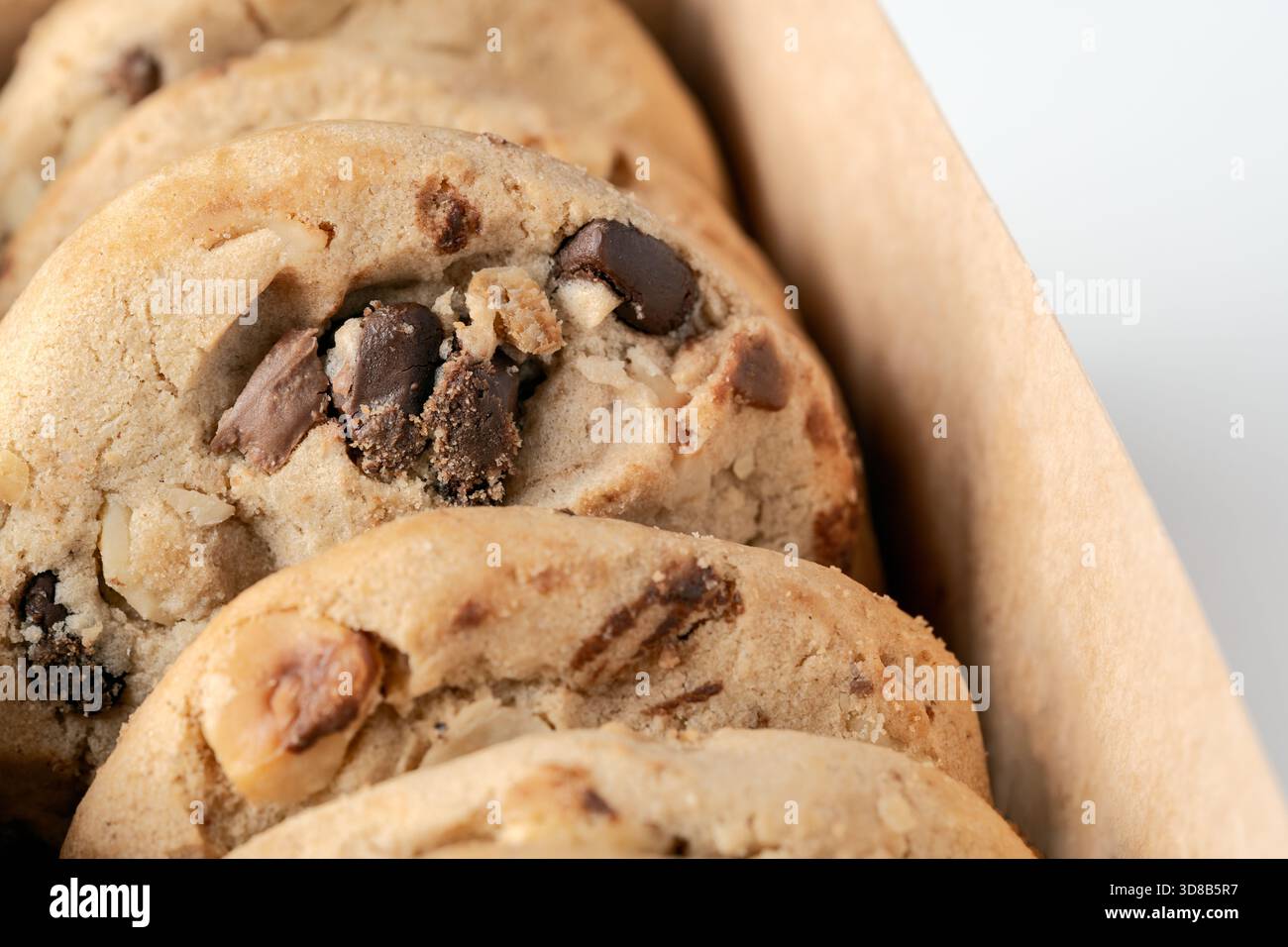 Primo piano di biscotti fatti in casa con pezzi di cioccolato e pezzi di noci in una scatola. Concentrati su ingredienti deliziosi Foto Stock