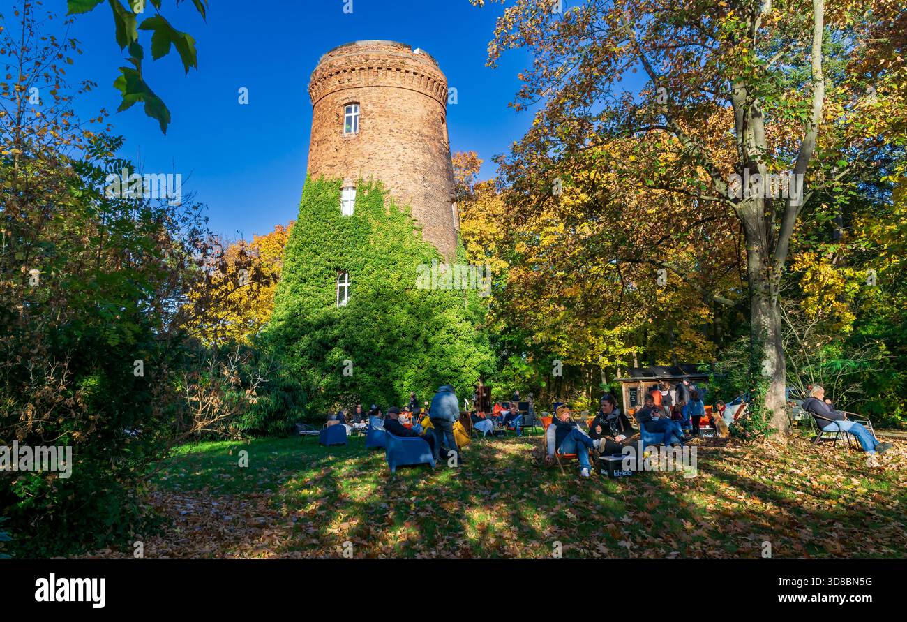 Scena autunnale al "Bar im Wasserturm" storica torre d'acqua in mattoni nel parco Obersee-Orankesee a Berlino Alt-Hohenschönhausen, Germania Foto Stock