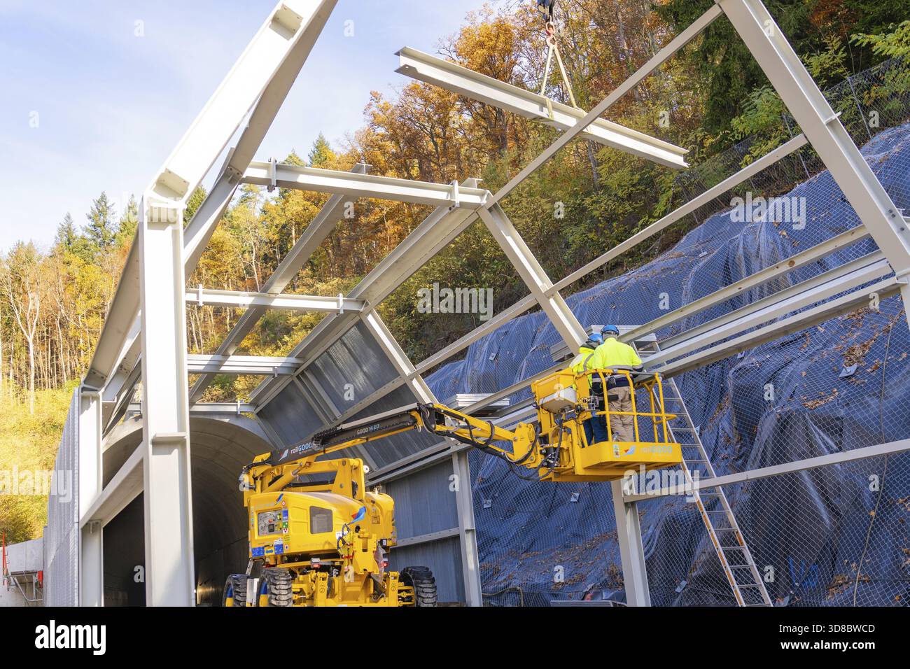 Lavoratori in un tunnel per la costruzione di ascensori circondato da colorati alberi autunnali, cantiere per la costruzione del tunnel di pipistrelli della Hermann Hesse Railway, Calw, Foresta Nera, Germania Foto Stock