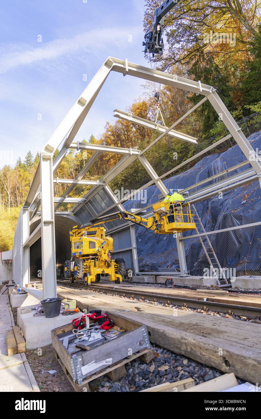 Lavori di costruzione all'ingresso di un tunnel in autunno con attrezzature da costruzione gialle e natura visibile sullo sfondo, Hermann Hesse Railway bat tu Foto Stock