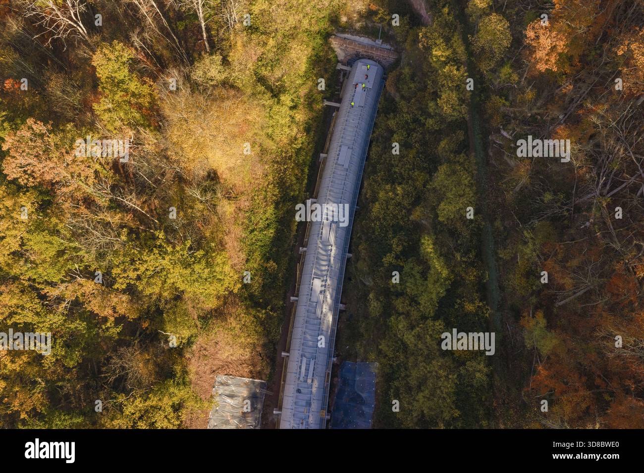 La foresta autunnale incornicia un progetto di costruzione di tunnel, mostrato in una colorata vista aerea, il cantiere Hermann Hesse Railway Bat Tunnel, Calw, Black F. Foto Stock