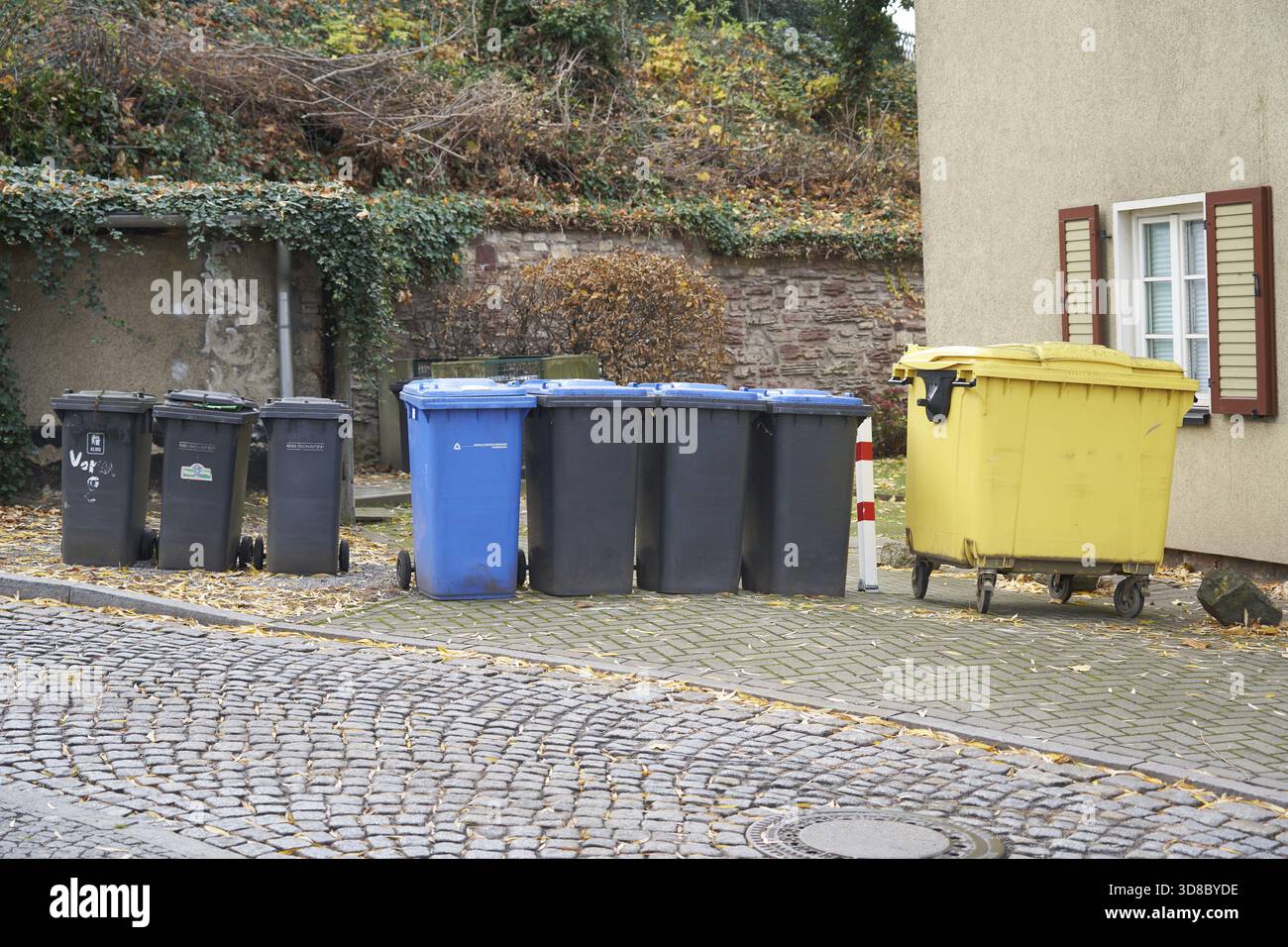 Separazione dei rifiuti con contenitore per rifiuti nero, contenitore per carta blu e contenitore per rifiuti giallo per imballaggi di vendita vuoti in plastica, metallo e materiali compositi Foto Stock