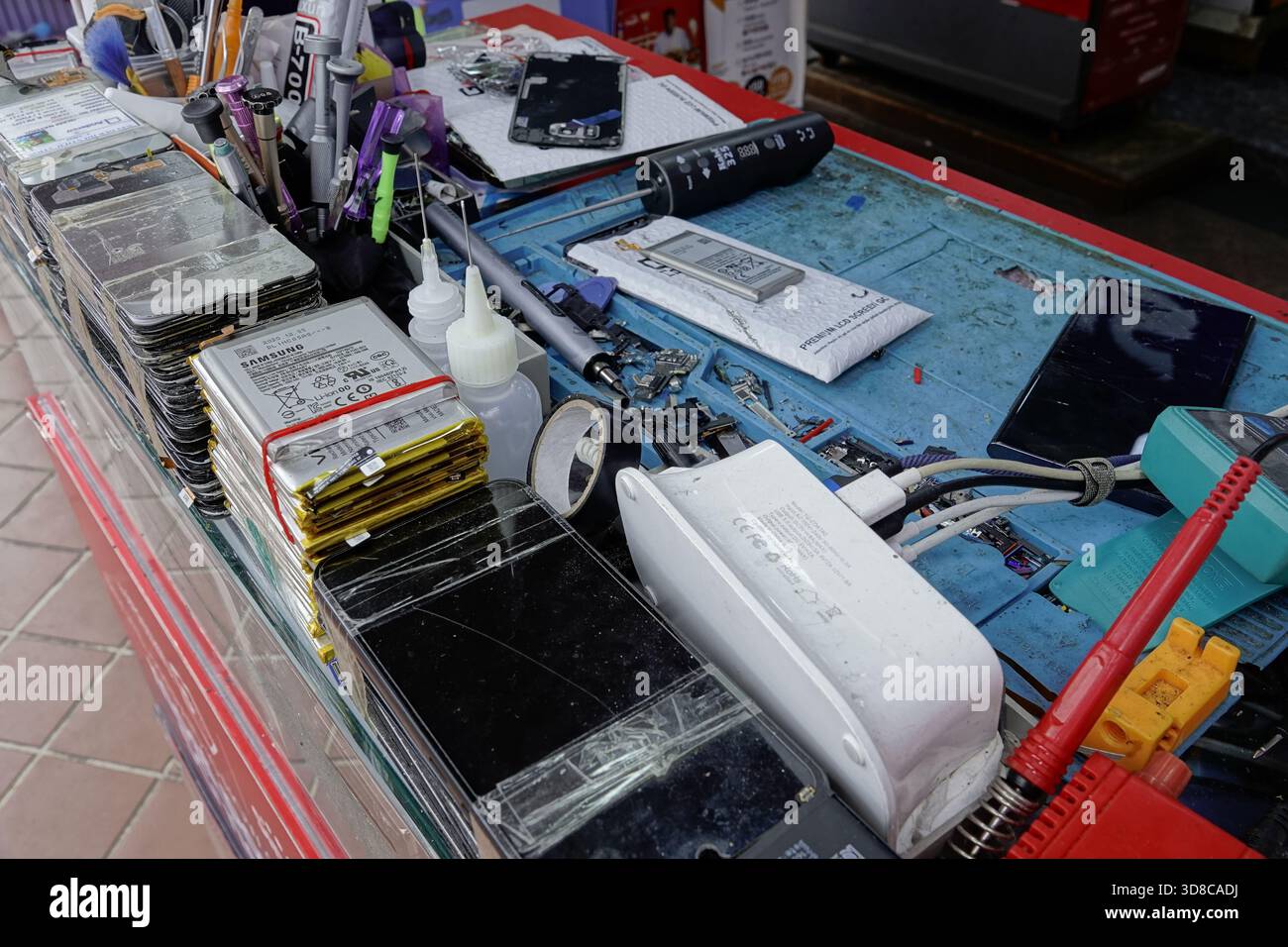 Singapore, 9 settembre 2025 pile di smartphone - iPhone e Android - si sono accumulate su un chiosco Internet/tech a Little India su Serangoon Road. Foto Stock