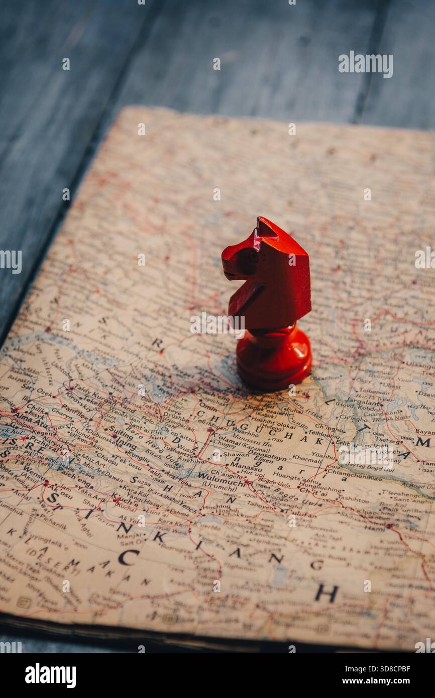 Pezzo rosso del cavaliere degli scacchi sulla vecchia mappa Foto Stock