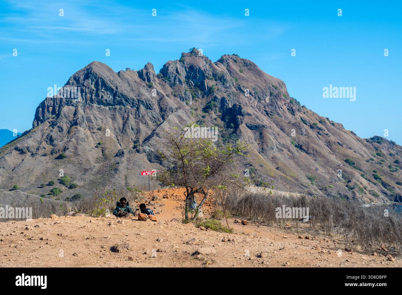 I Rangers si trovano accanto al percorso in salita, l'Isola Padar, il Parco Nazionale di Komodo, Indonesia Foto Stock