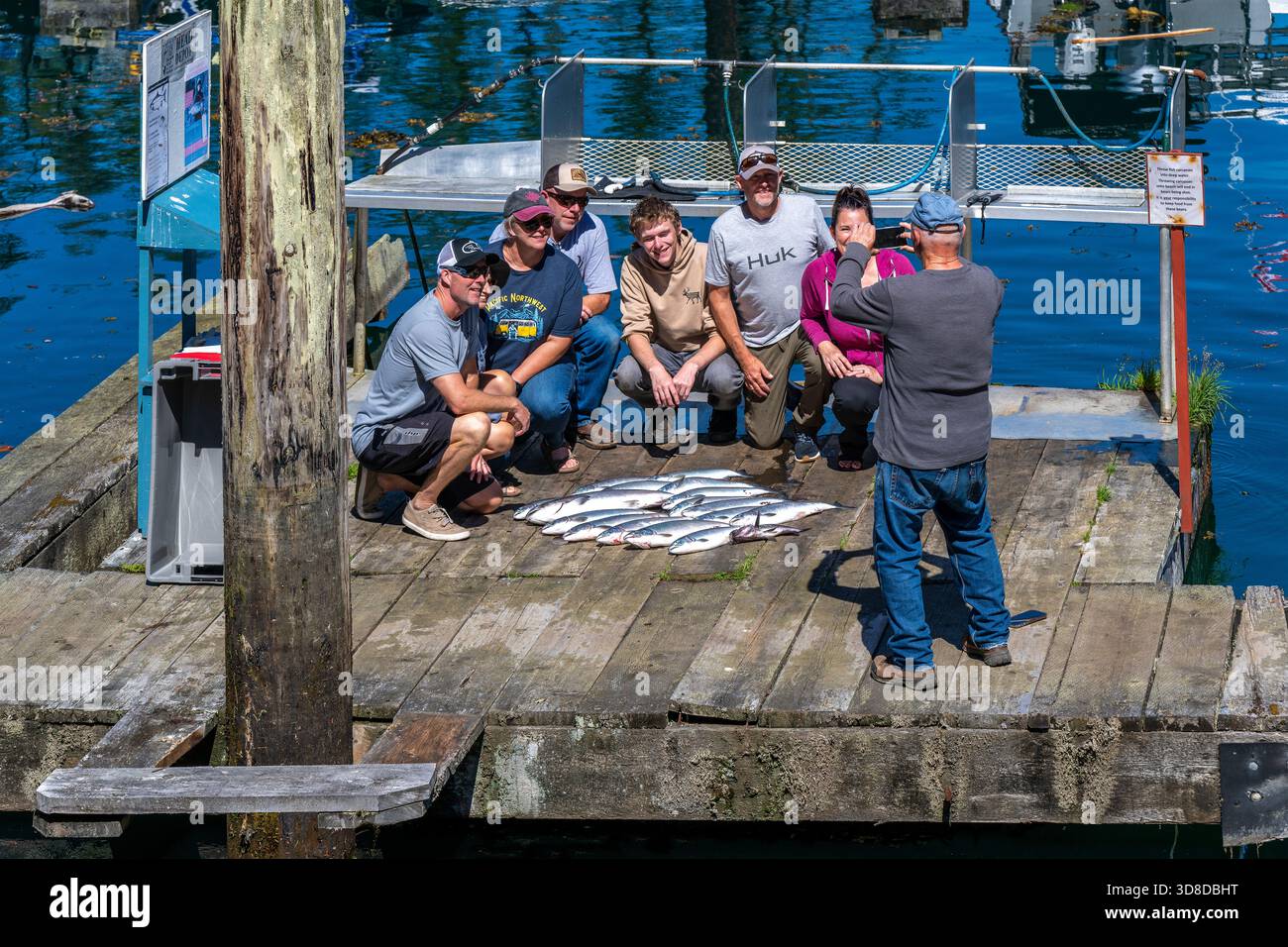 I pescatori e il loro pescato del giorno con calici e salmoni di coho, Telegraph Cove Marina, Vancouver Island, British Columbia, Canada. Foto Stock
