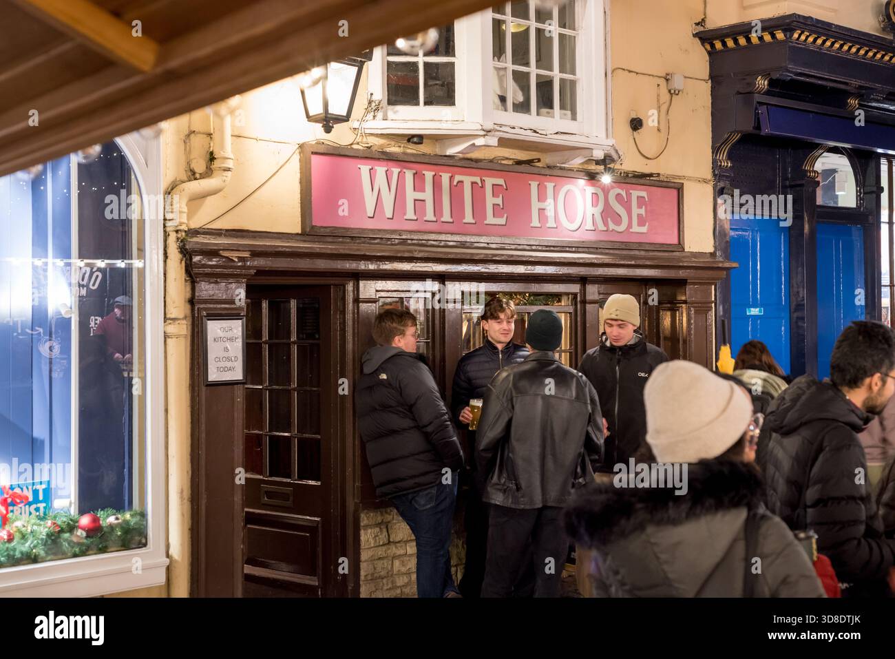 Giovani che tengono birra fuori dal pub White Horse nella città di Oxford di notte Foto Stock