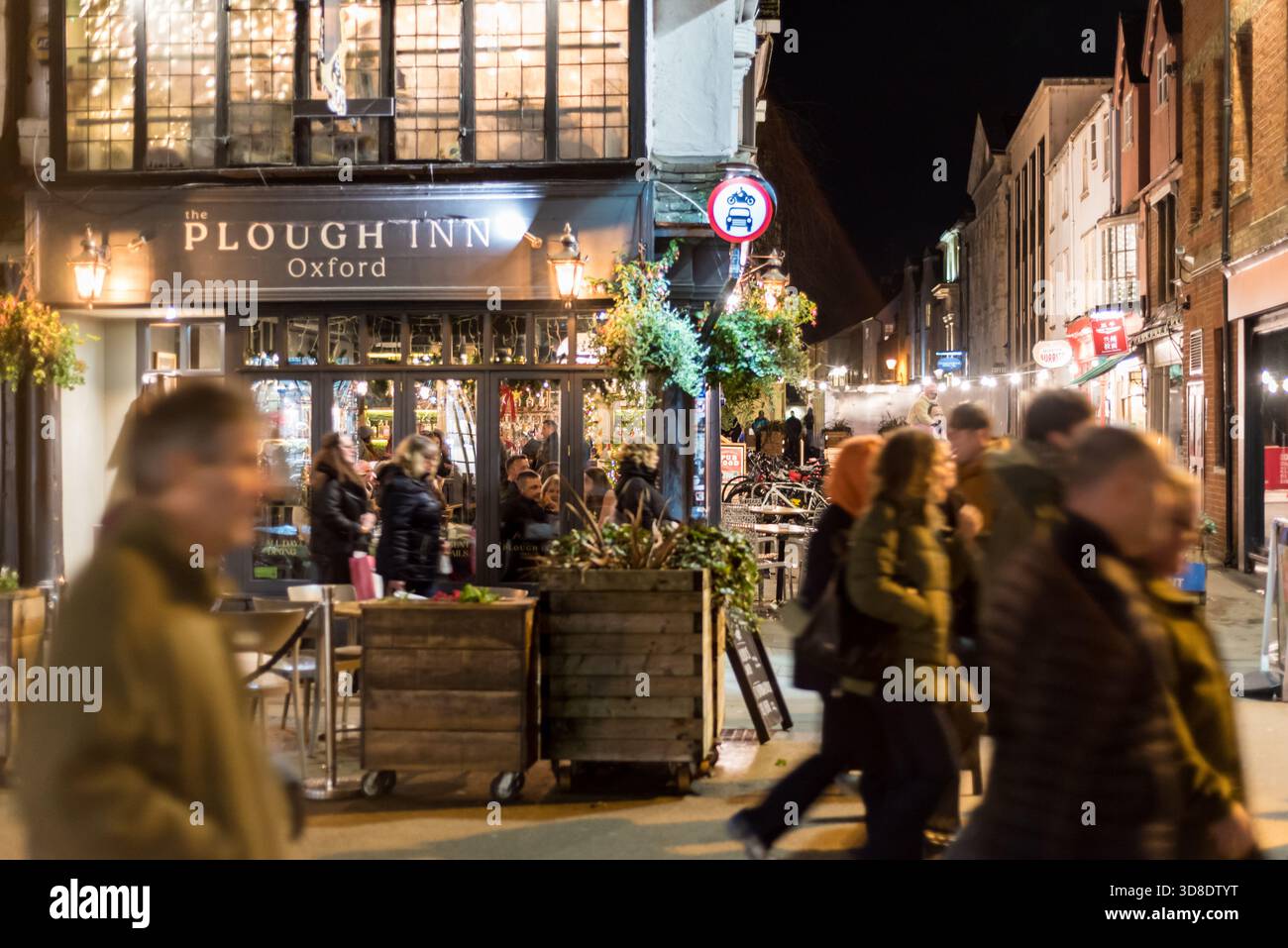 La città di Oxford di notte con il pub Plough Inn e la gente che cammina Foto Stock