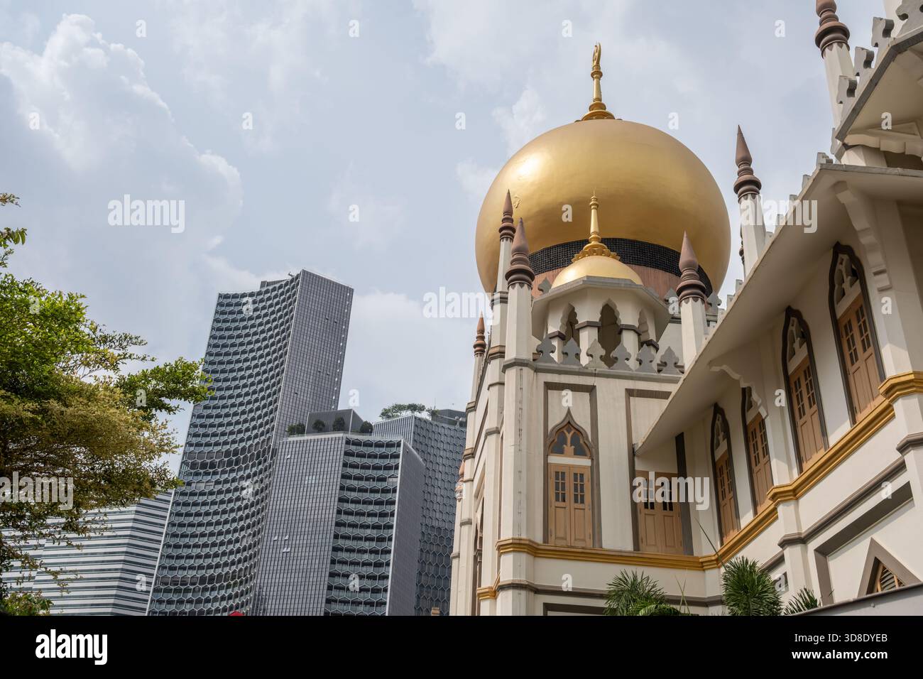 La splendida cupola dorata della Moschea del Sultano si erge in modo prominente contro i moderni grattacieli di Haji Lane, Singapore, evidenziando la diversità architettonica Foto Stock