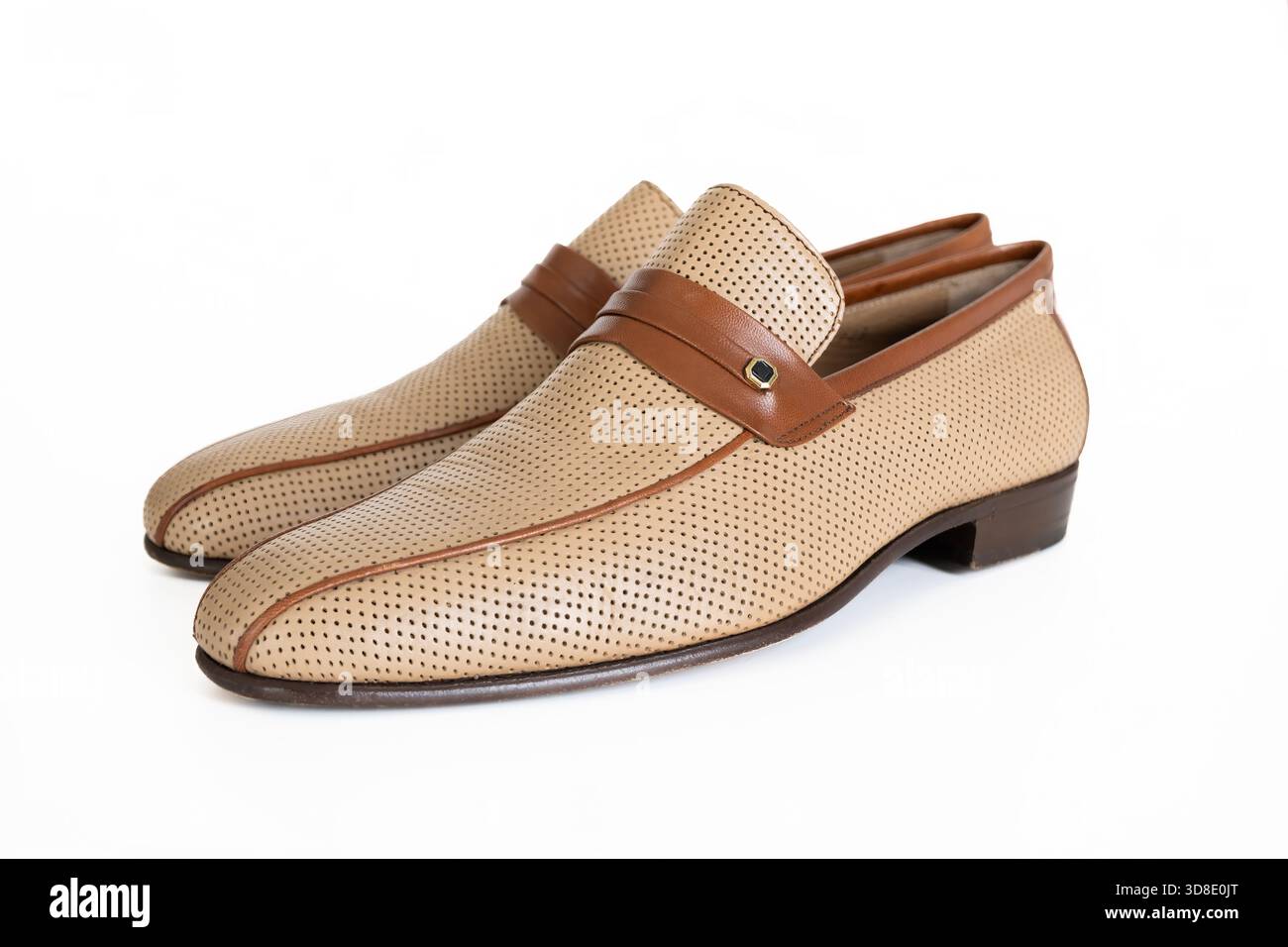 Eleganti mocassini beige dal design traforato e dettagli in pelle marrone, perfetti per ambienti sia informali che formali, per un comfort maggiore Foto Stock