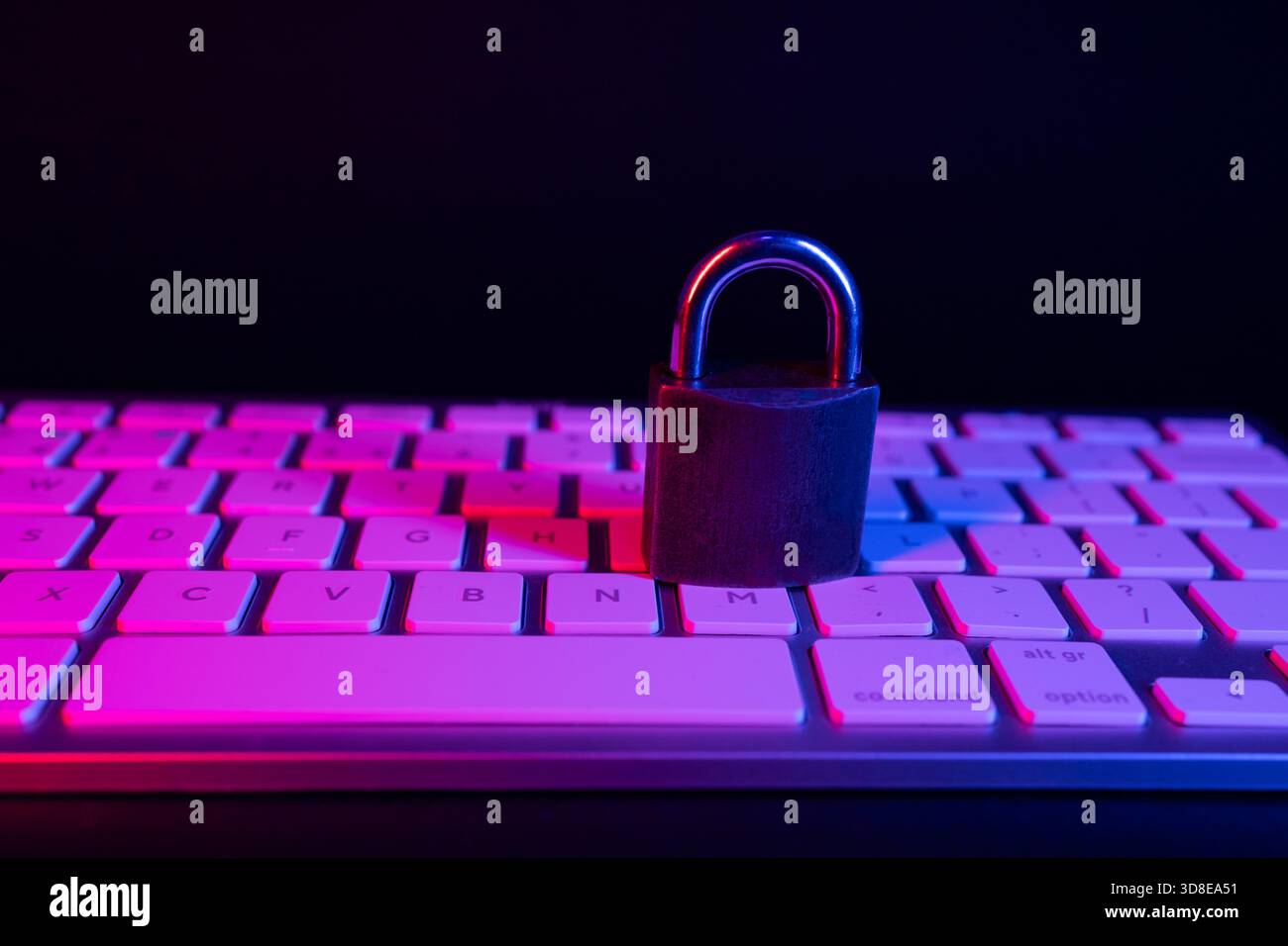 Un lucchetto è posizionato in modo sicuro su una tastiera, simboleggiando la sicurezza Internet. La scena presenta colori vivaci e scarsa illuminazione, sottolineando l'importanza di Foto Stock
